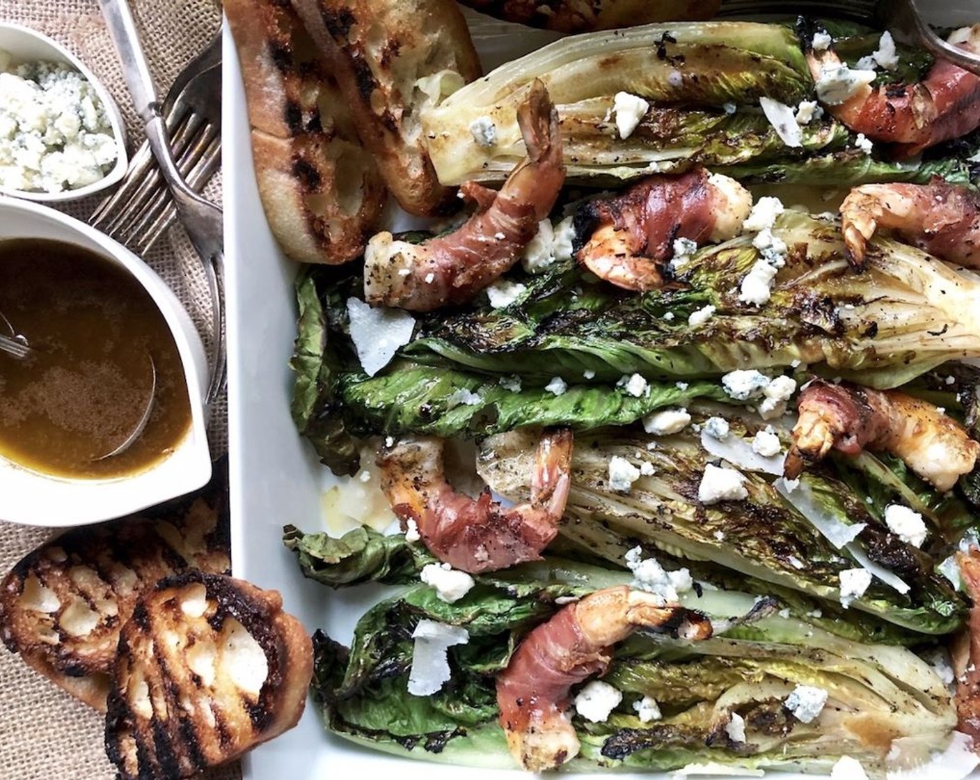 step 8 Place the grilled lettuce on a platter cut side up. Sprinkle with Shaved Parmesan Cheese (to taste) and Blue Cheese (to taste). Drizzle the balsamic dressing lightly over the top and season with kosher salt and freshly ground black pepper to taste.