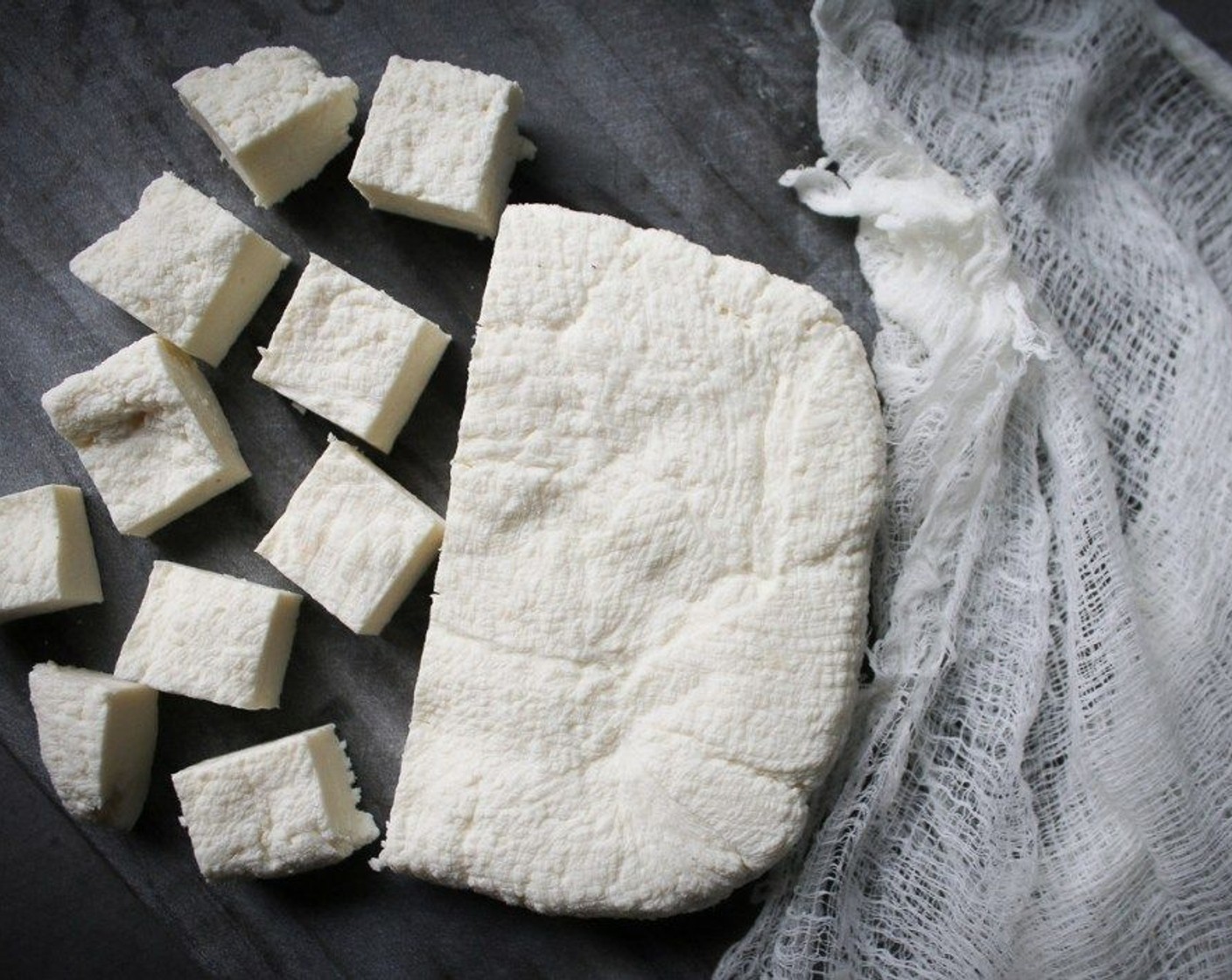 step 4 Place paneer wrapped in cheesecloth onto a plate. Place another plate or a cutting board on top with a heavy book. Press the cheese for 1 to 4 hours. Cut into 1-inch squares and either refrigerate or freeze until ready to use!