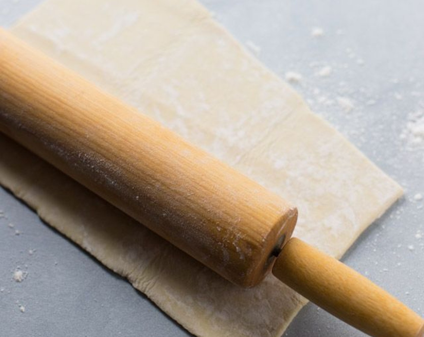 step 1 Take one sheet of Puff Pastry (1 sheet) dough and cut it in half. Roll each half until they double in size.