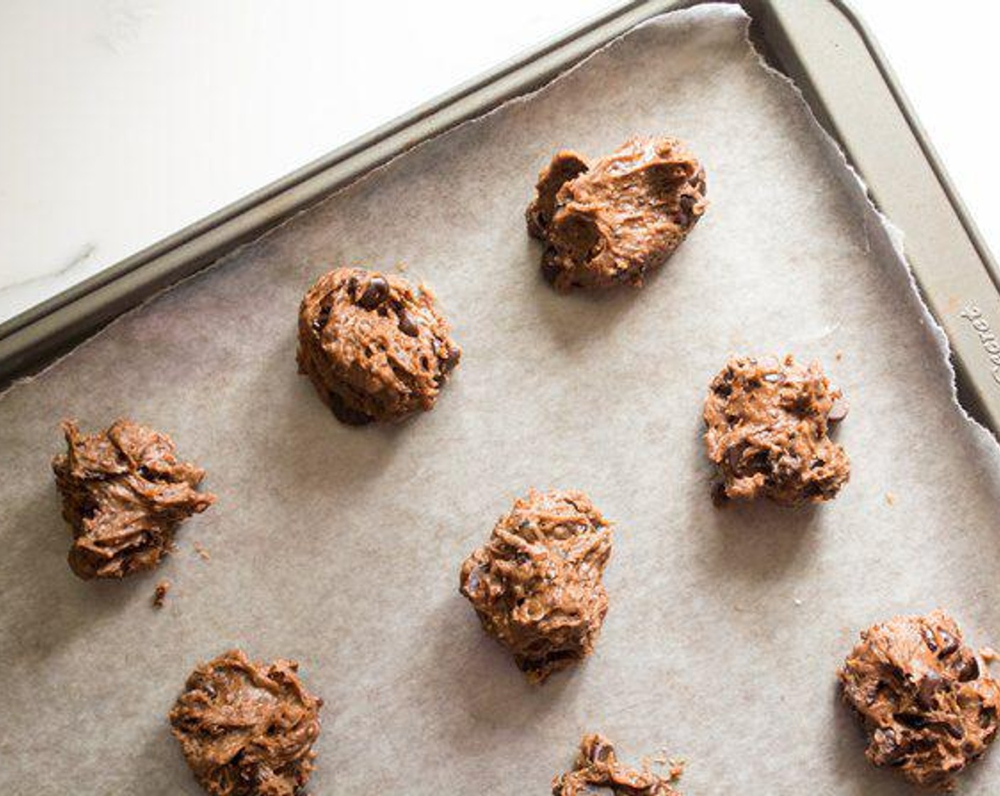 step 4 Roll dough into 2-inch balls and place on parchment-lined baking sheet. Press slightly to flatten.