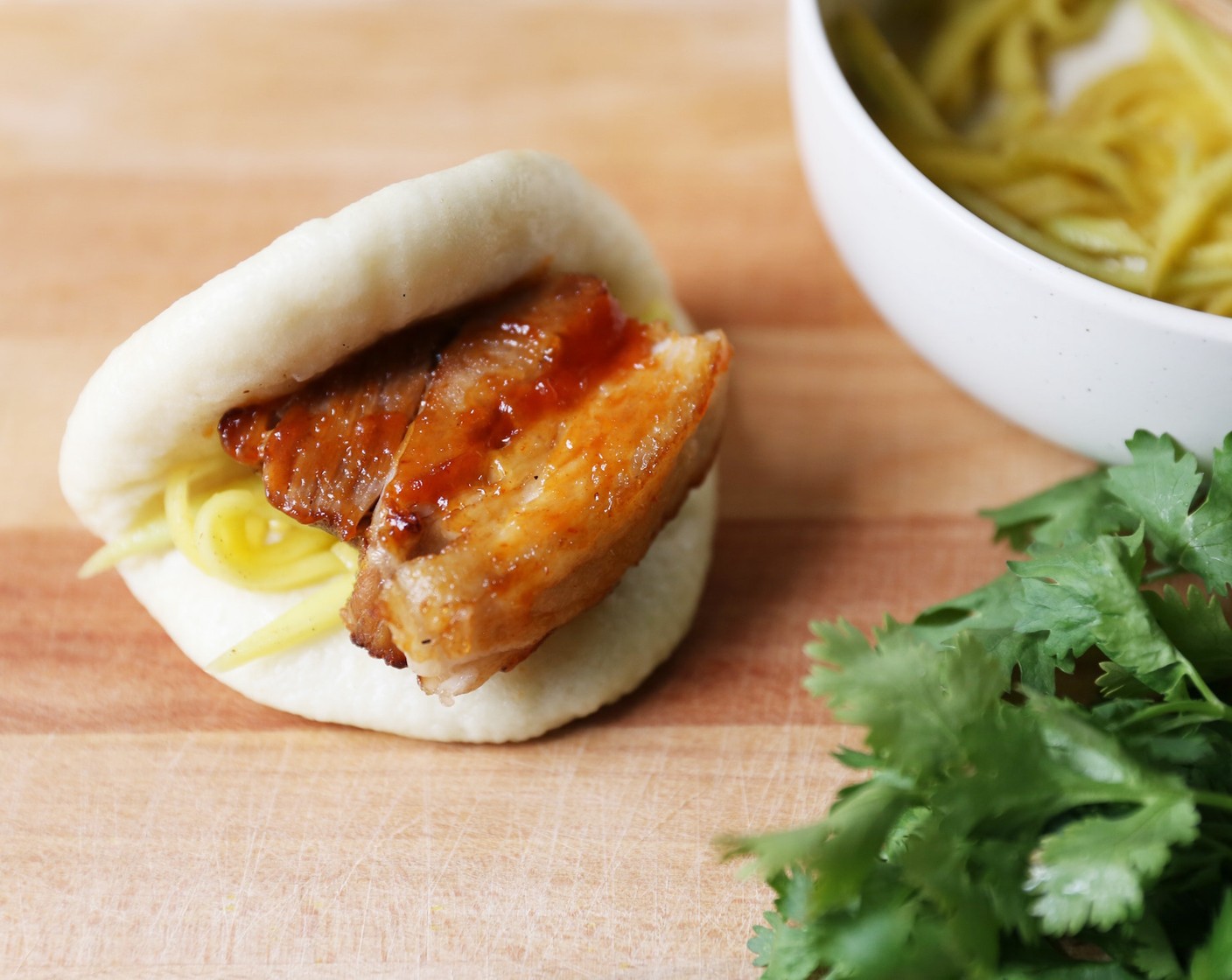 step 11 Dress the Green Mango (1 cup) with 2 tsp of Lemon Juice, Salt (to taste) and Korean Chili Flakes (to taste). Place inside each of the Steamed Buns (6), placing a piece of pork on top of it.