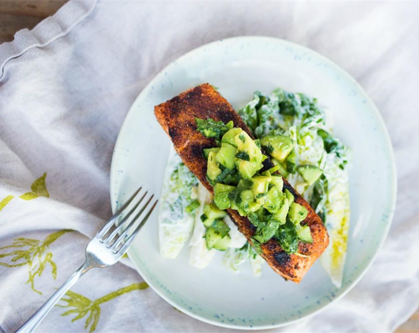 step 9 Place salmon on top, then spoon avocado salsa over top. Serve with lime wedges and cilantro sprigs. Enjoy!