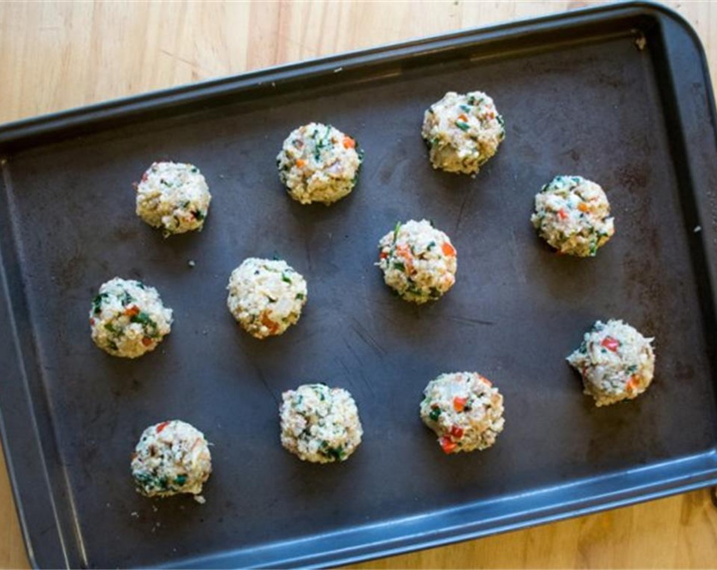 step 7 Take heaping spoonful of mixture into your hand and roll into “meatball” form and place on a greased baking sheet. Continue to do this until all meatballs have been formed. Bake the meatballs for 25 to 30 minutes, or until slightly golden.