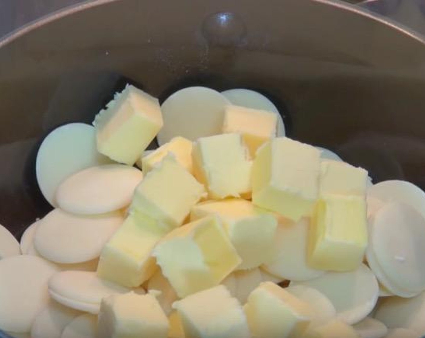 step 1 Put White Chocolate (1 3/4 cups) and Butter (2.5 oz) in a double boiler, allow it to melt and stir occasionally. Then take the bowl out of the pot and cool off the chocolate for 10 minutes.