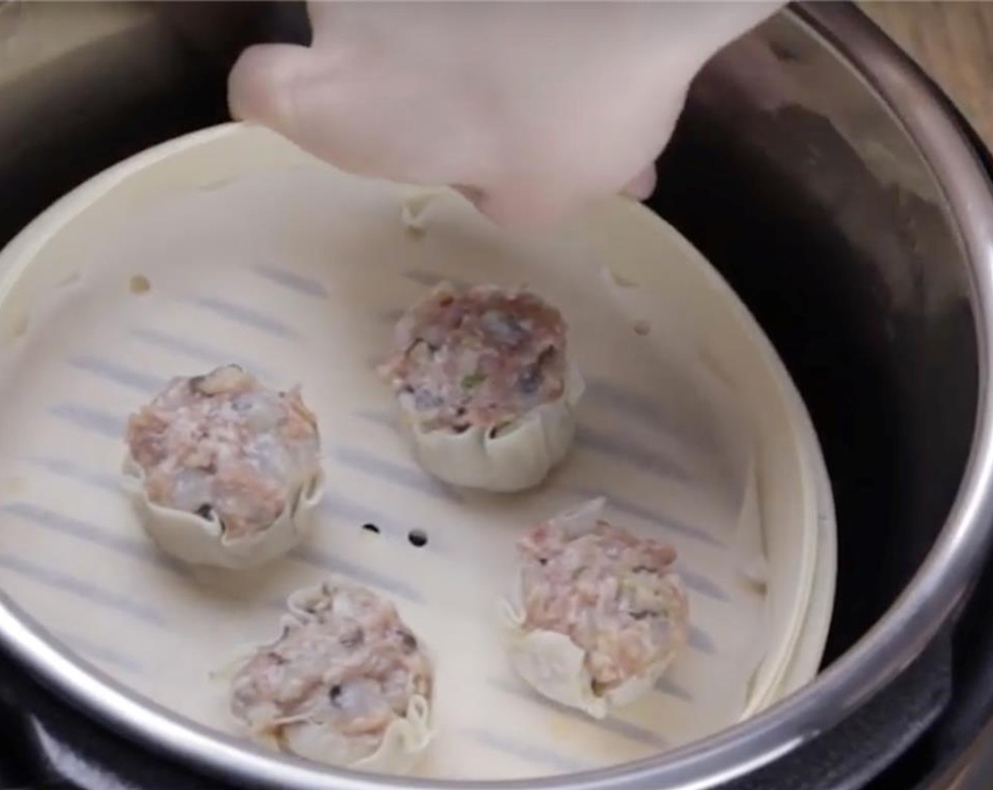 step 9 Place a parchment liner into the bamboo steamer, then place the Shumai on the liner. Close the bamboo steamer lid.