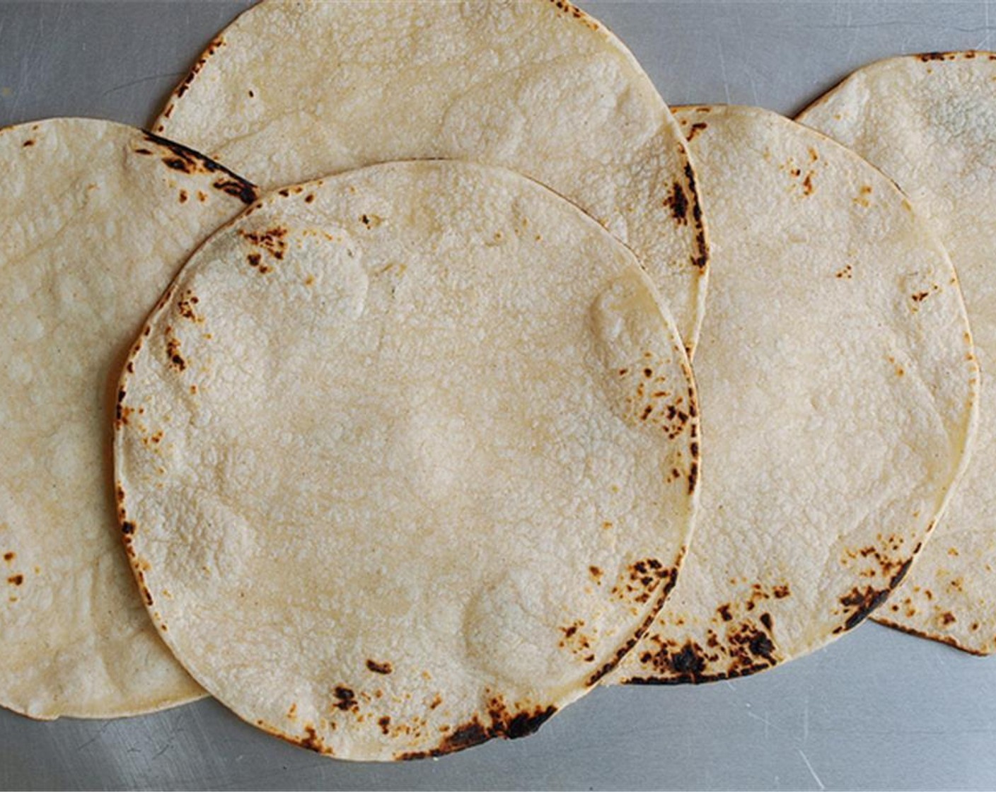 step 2 Warm your White Corn Tortillas (5) carefully on the stove top over an open flame to give it some charring on the edges.