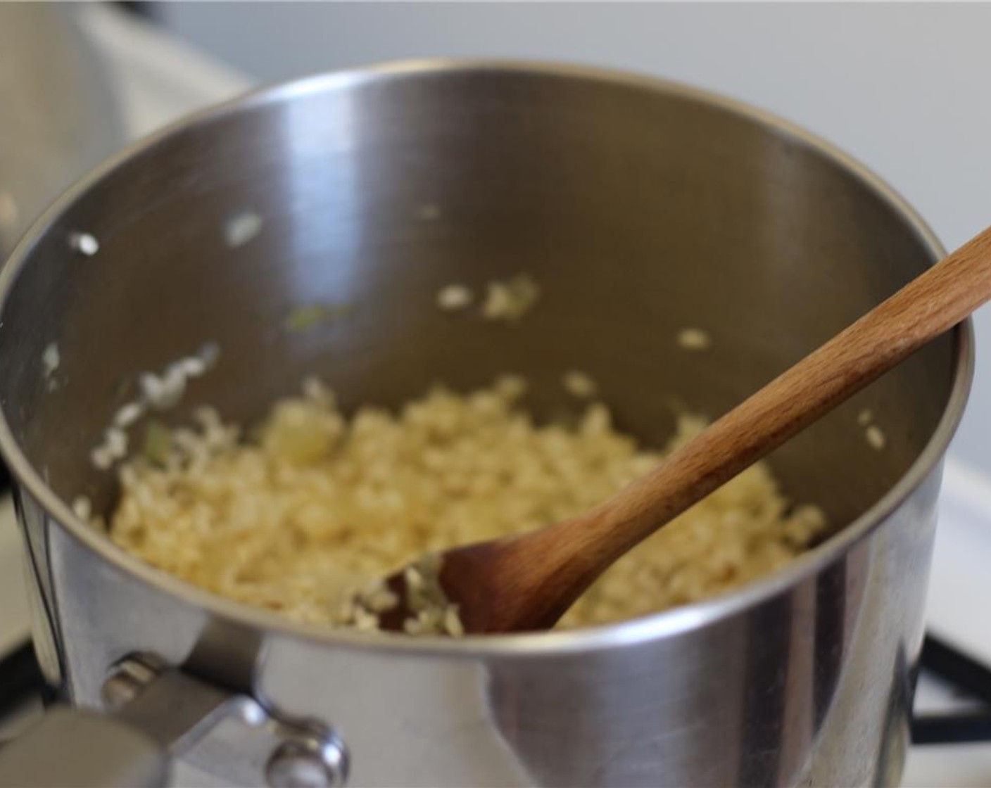 step 12 Pour in ¼ cup of stock at a time into the risotto, stirring often. Allow each ladle of liquid to cook into the rice before adding more liquid.