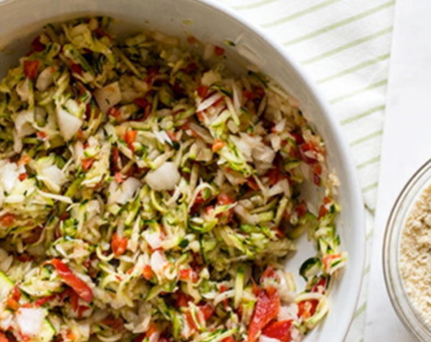 step 4 Do the same with the onions and peppers by sprinkling with salt and placing in the colander. After 5-10 minutes squeeze the water out, and add to the bowl with zucchini. Add Egg (1) to the mixture and stir to combine.