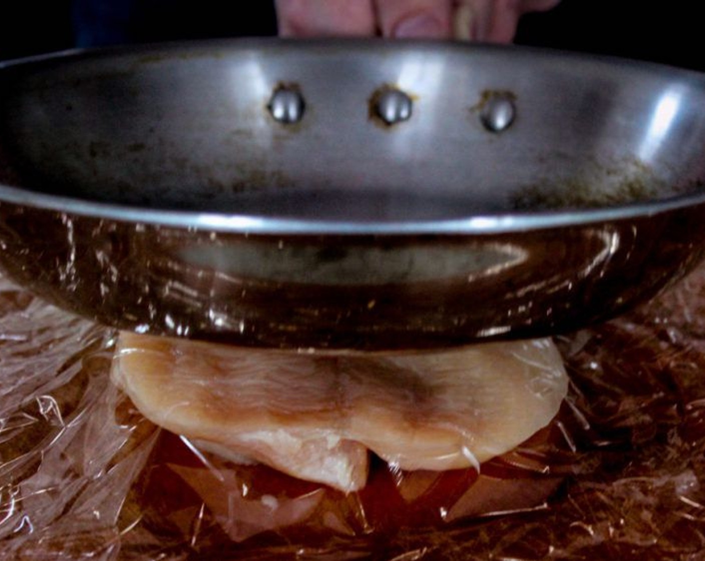 step 5 Put the chicken between 2 pieces of saran wrap and flatten it with a frying pan, a flat kitchen mallet or the bottom of a flat surfaced bowl.