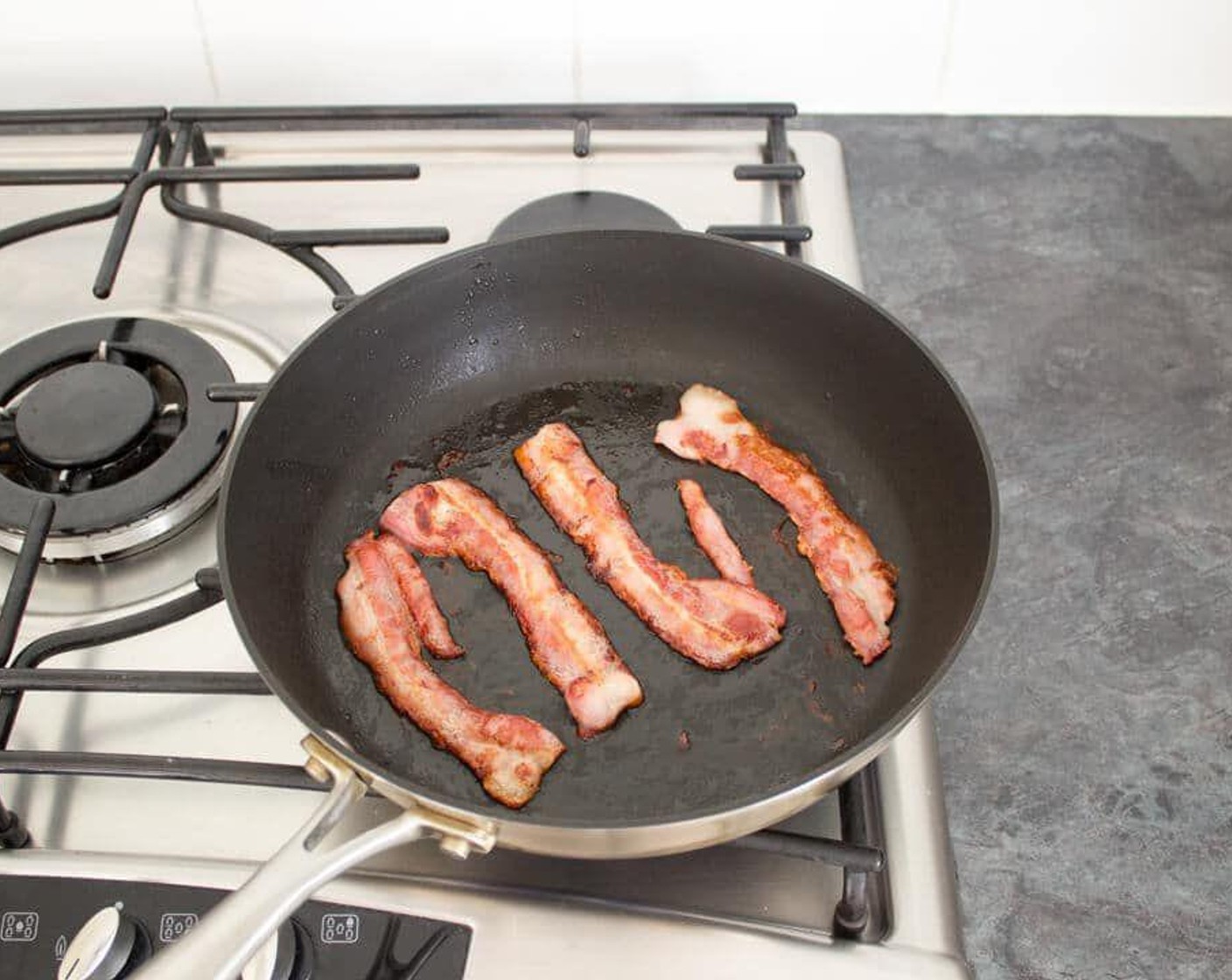 step 2 Next, lay in the Smoked Bacon (4 slices) and fry to your liking, turning once to ensure even cooking. Remove the bacon from the pan and set it to one side to keep warm. Keep the pan over medium heat.