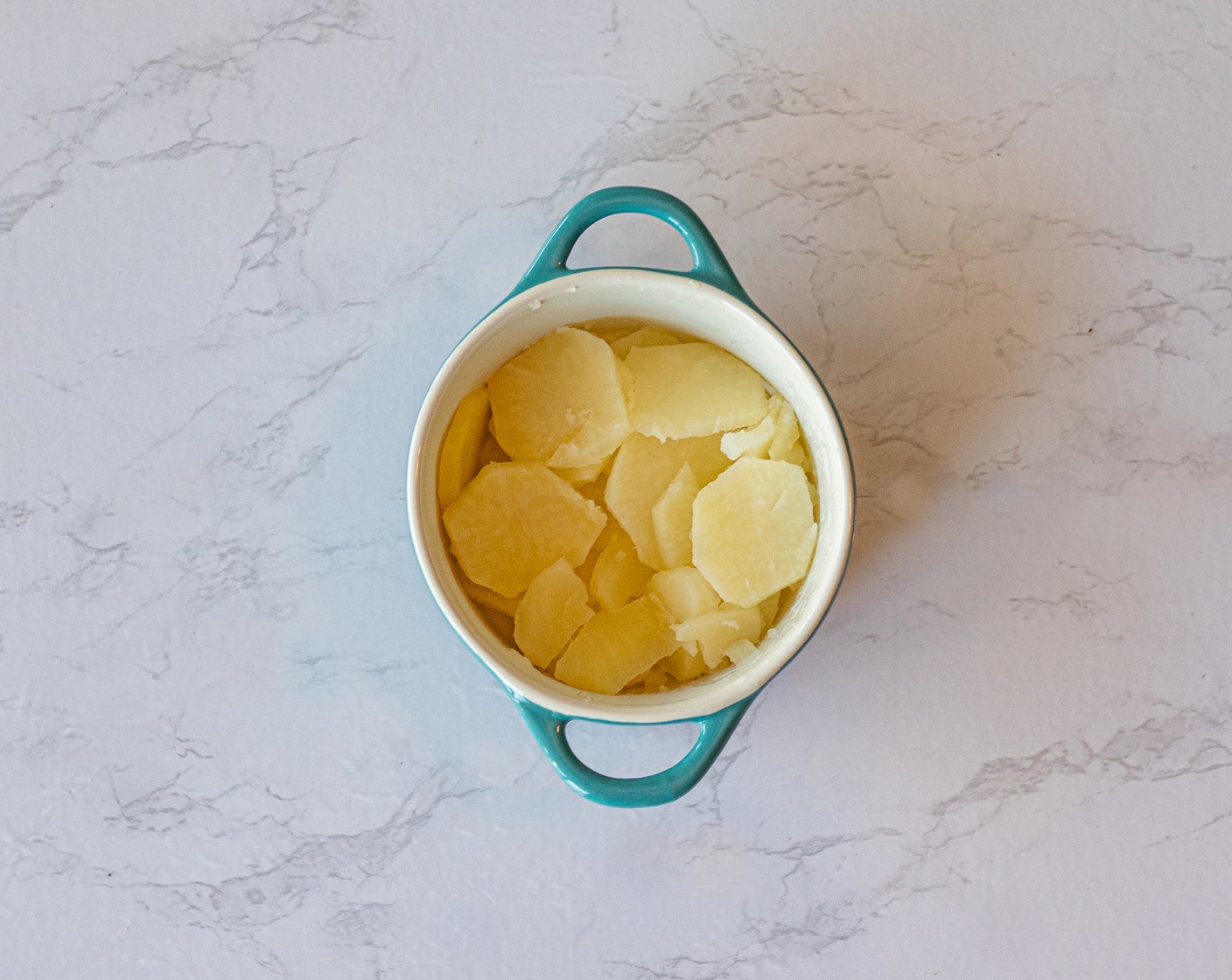 step 5 In the meantime, add a layer of boiled potatoes to each of the 4 mini casserole dishes.