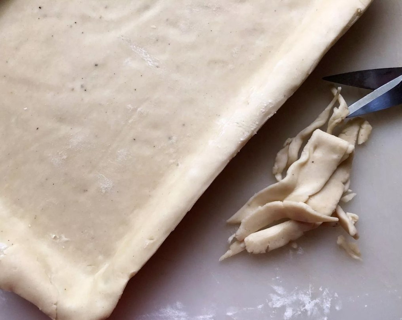 step 9 On a floured surface, roll one batch of pastry dough to a 17x12-inch rectangle about 1/8-inch thick. Fold into quarters, then unfold into a 15x10x1-inch baking pan. Ease into sides and corners. Trim to 1/2-inch beyond pan edges. Cover and chill trimmings.