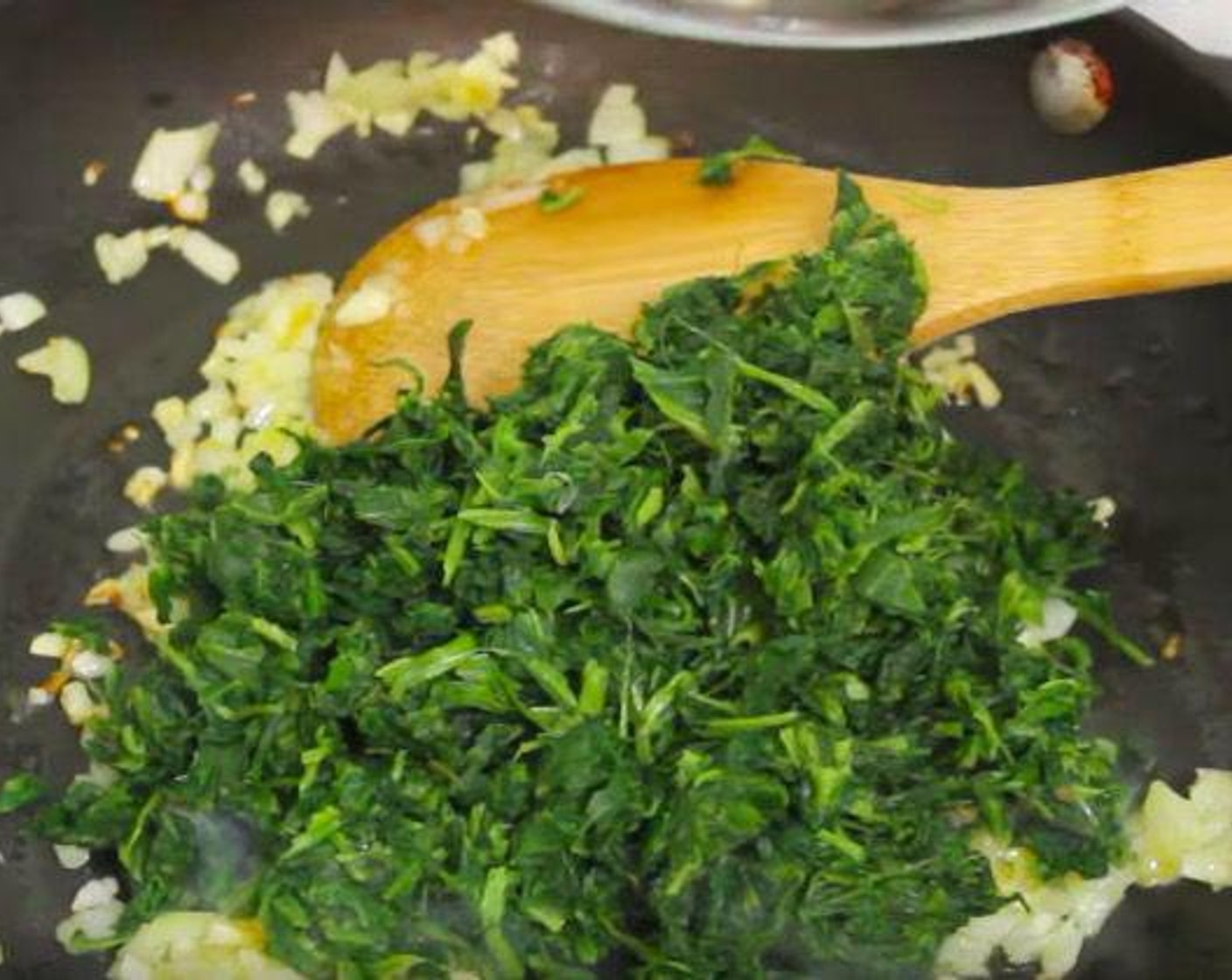 step 2 In a pan, add Olive Oil (2 Tbsp), and soften the Onion (1) and Garlic (2 cloves). Then, add Frozen Spinach (2 cups) stir and season with Salt (to taste) and Ground Black Pepper (to taste). Cook for about 1 minutes and stir constantly. Transfer to a bowl and set aside.