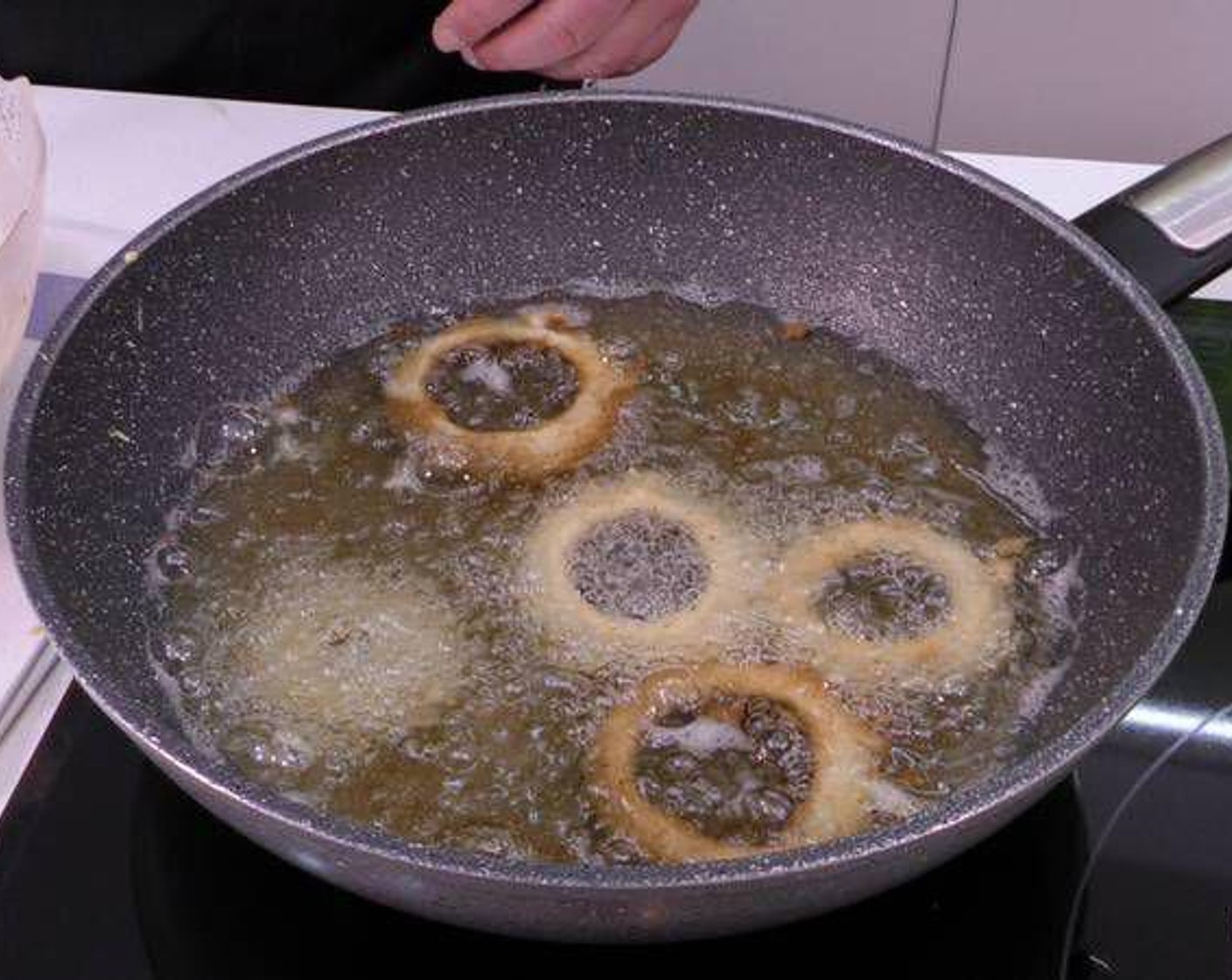 step 6 In a large frying pan, add enough Olive Oil (as needed) to cover the rings and set to medium-high heat. Once hot, fry the battered onion rings until golden brown and crispy.
