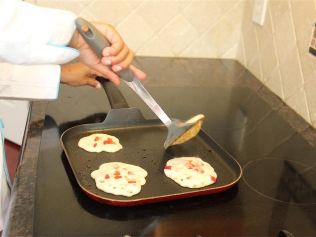 Step 6 of Three Layer Strawberry Pancakes Recipe: Make sure to wait until the pancake's edges are dry and the top of the pancake has bubbles rising up before you flip the pancakes.