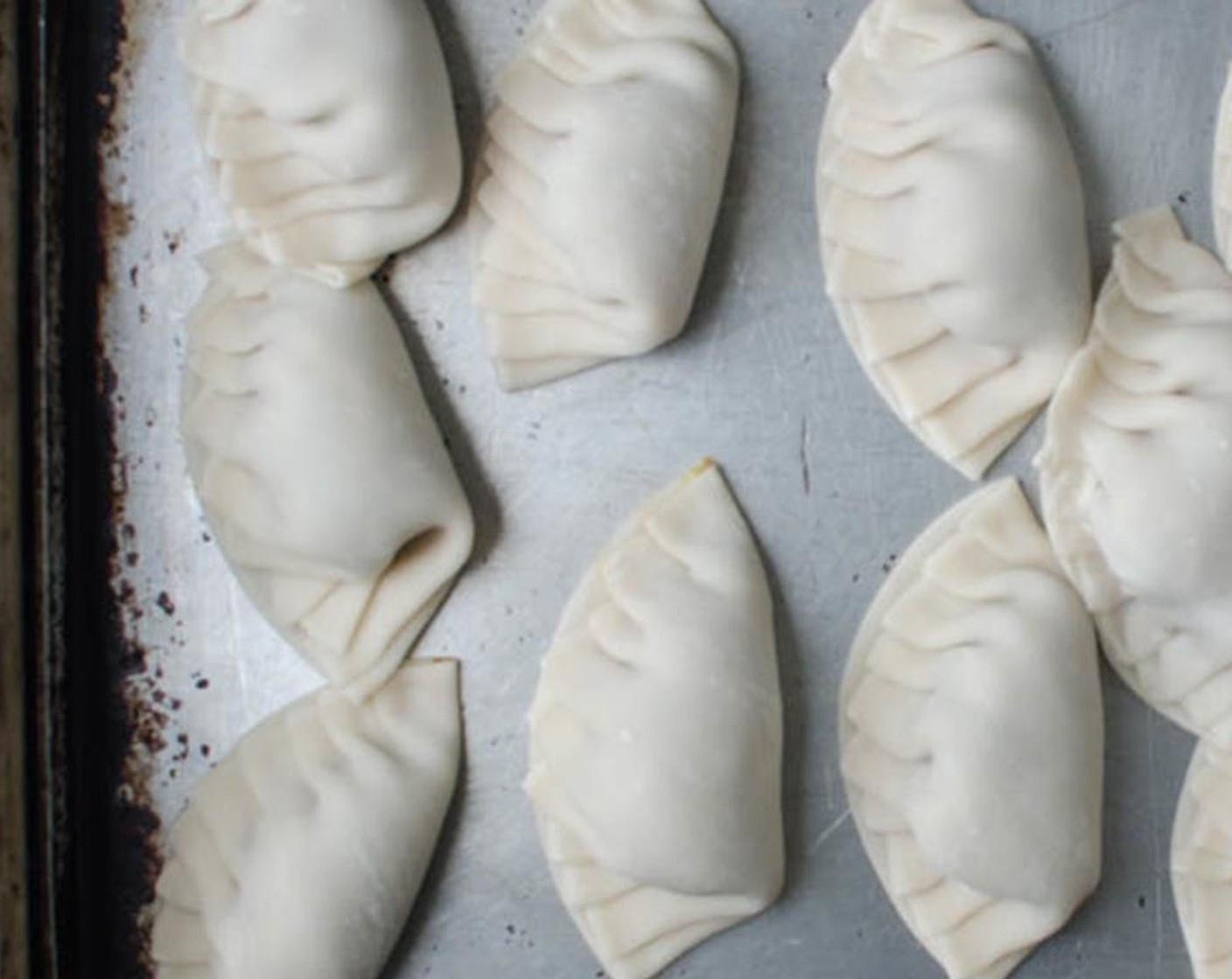 step 6 Place the dumplings on the baking sheet and continue assembling the rest.