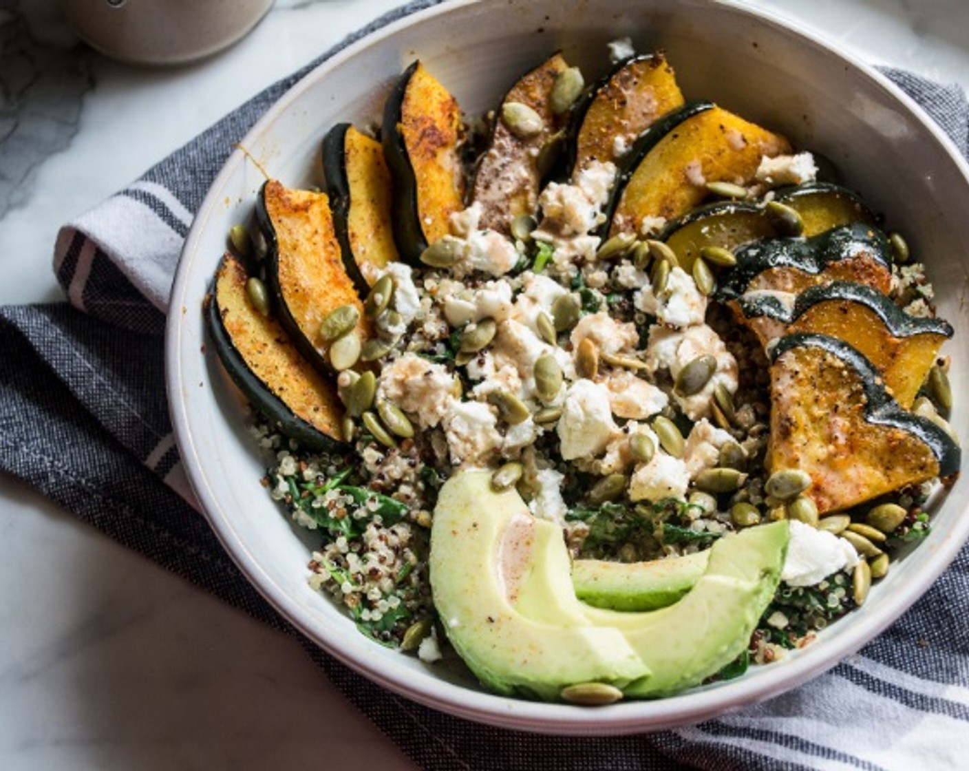 step 7 Once quinoa and squash have cooked, assemble power bowls, starting with a layer of the quinoa and spinach mixture, then add Acorn Squash, Pepitas (2 Tbsp), Goat Cheese (3 Tbsp), Avocado (1/2), and finally drizzle with Creamy Apple Cider Balsamic Vinaigrette.