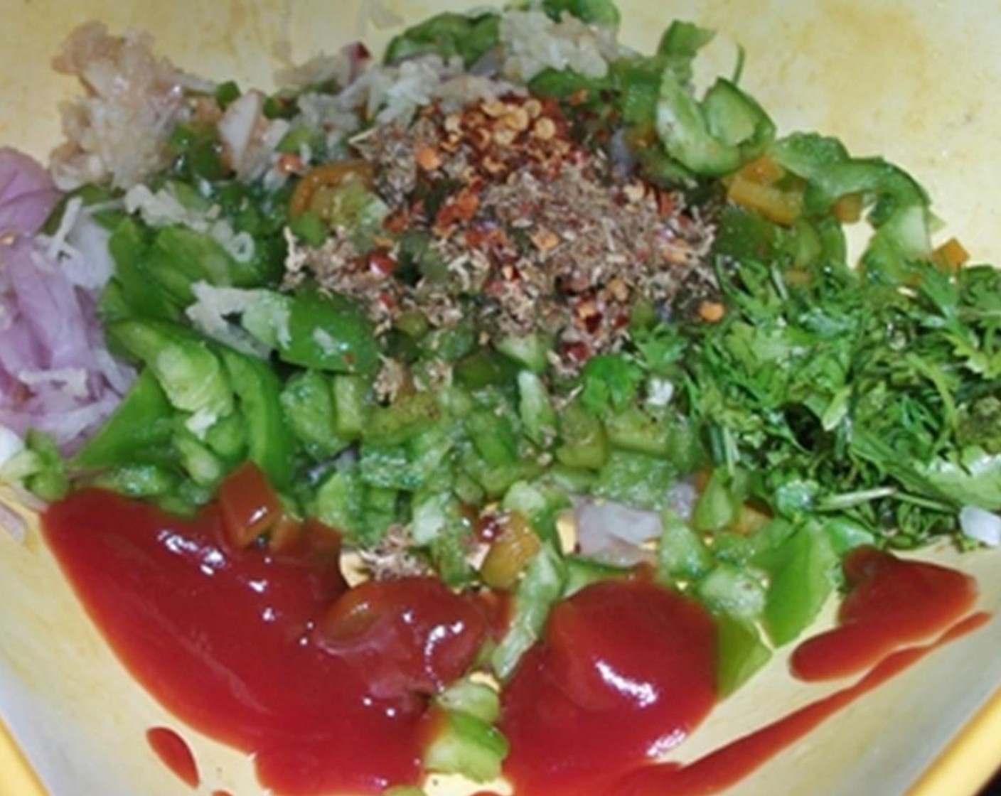 step 2 In a mixing bowl, add Onion (1), Bell Pepper (1), Fresh Parsley (2 Tbsp), Ketchup (1 Tbsp), Garlic (2 cloves), Salt (1/4 tsp), Ground Black Pepper (1/4 tsp), Crushed Red Pepper Flakes (1 tsp), and Dried Oregano (1 tsp).