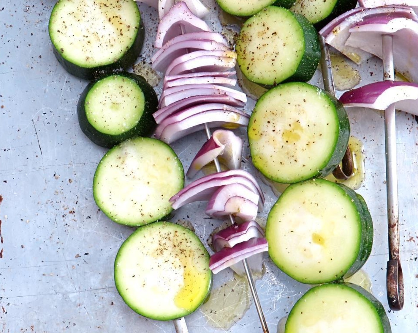 step 7 If grilling, skewer the zucchini slices (skewer on the thin side, so that more of the flesh can get the char of the grill). Separate the layers of onion and loosely skewer.
