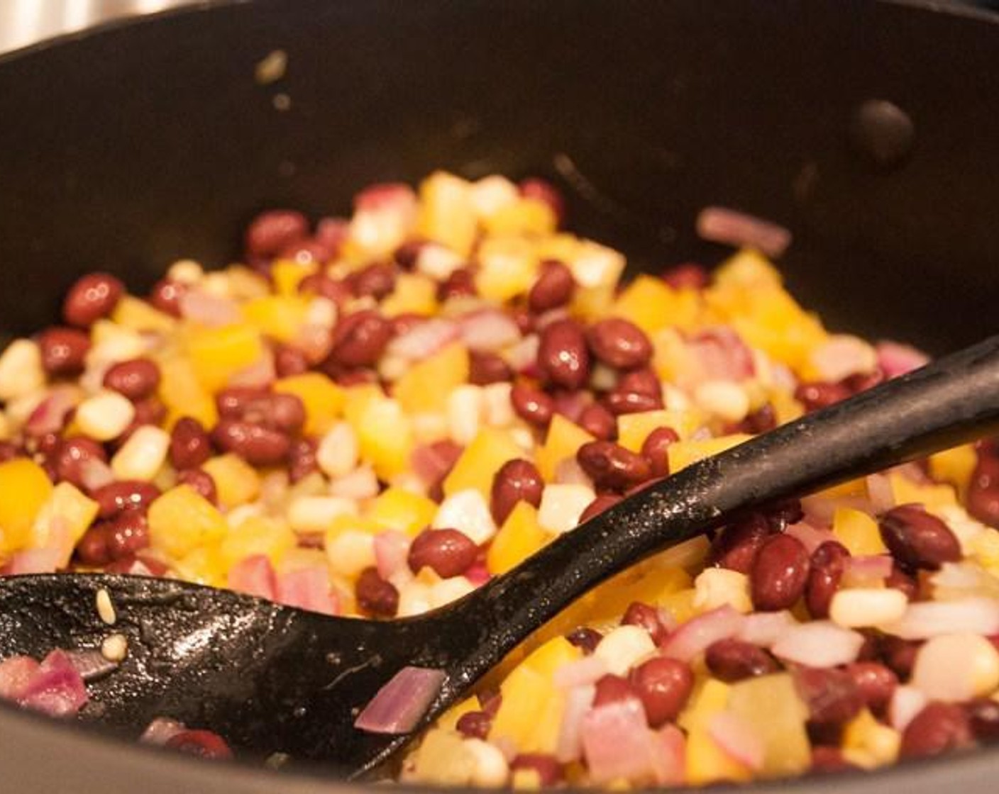 step 2 Meanwhile, saute Onion (1), Yellow Bell Peppers (3), Frozen Corn Kernels (1/2 cup), Ground Cumin (1 tsp), Salt (1/2 tsp), Black Beans (2 cans), and Mild Diced Green Chiles (1 can).