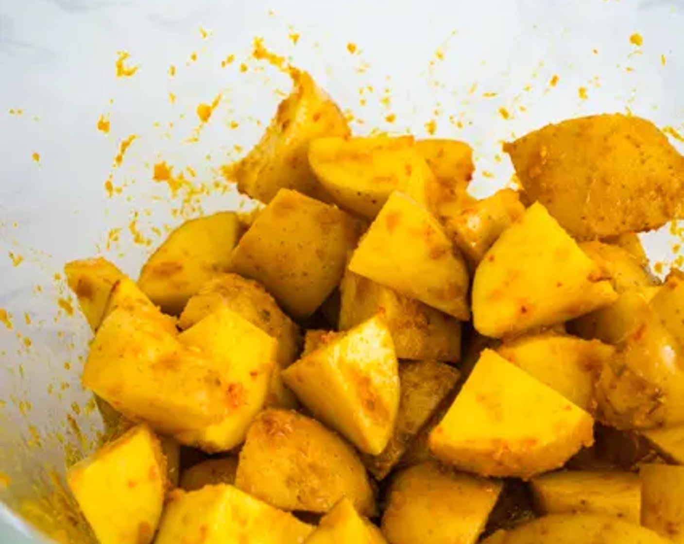 step 4 Pour the curry paste mixture over the potatoes. Mix thoroughly so each potato is properly coated in the curry paste. Let the potatoes marinate for about 30 minutes.