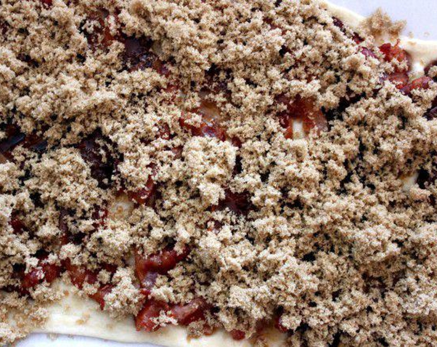step 2 Top the dough with a thin layer of Maple Syrup (1/2 cup), and all the crispy Bacon (1 lb).  Now add another thin layer of the Syrup onto the Bacon and cover it with all of the Brown Sugar (1 cup) and Cayenne Pepper (1 pinch) mix.