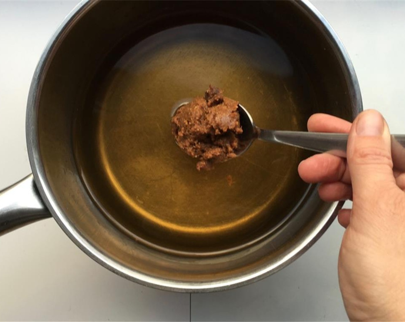 step 4 Pour the Water (3 cups) in a large saucepan and add the Red Miso Paste (2 Tbsp) and half of the Dark Soy Sauce (1/2 Tbsp).