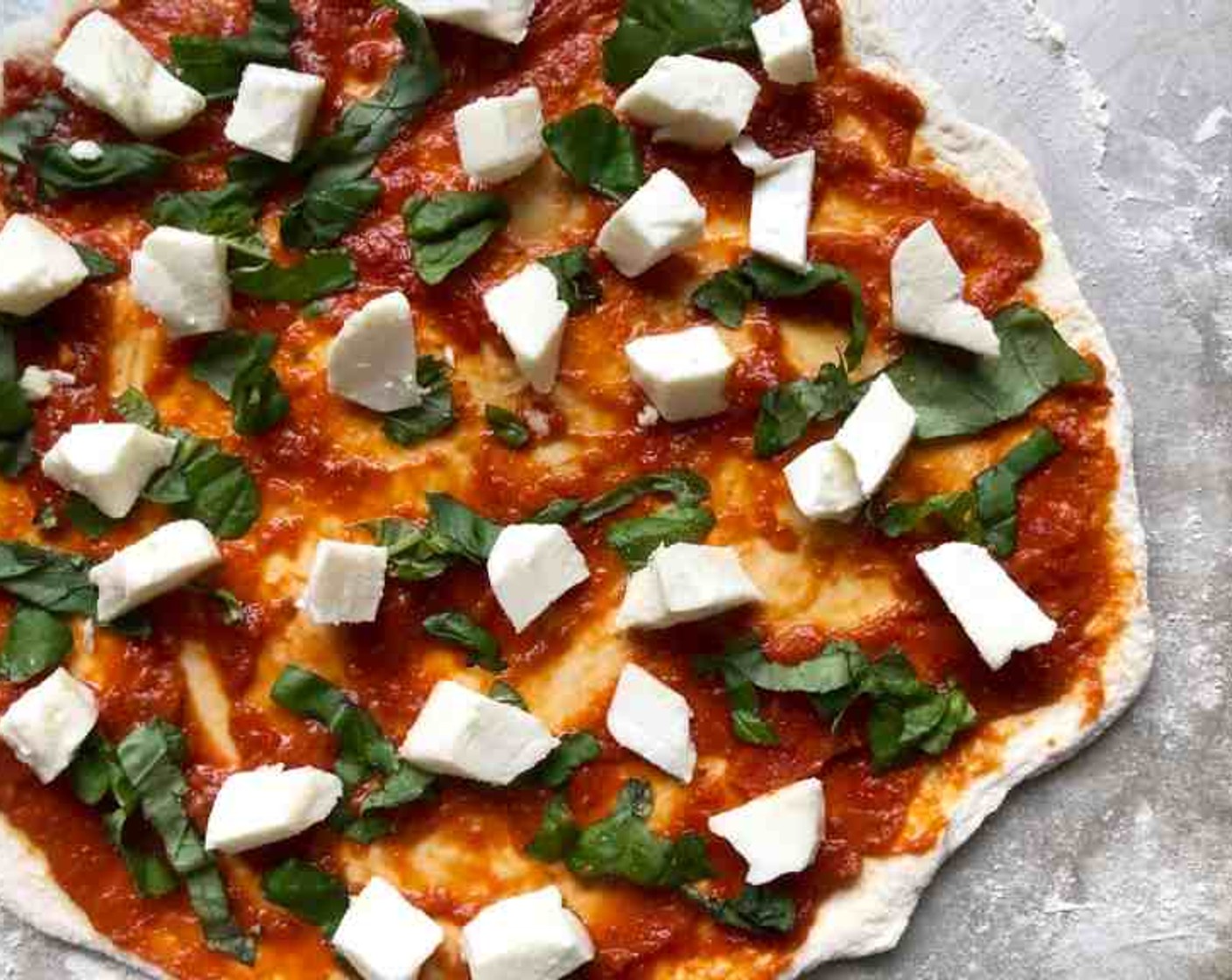 step 11 Spread Tomato Sauce (1/3 cup) over the dough, leaving about a half-inch border then add the Fresh Basil Leaves (6) and Mozzarella Cheese (3/4 cup). Drizzle a little Olive Oil (as needed) over the pizza, if desired.