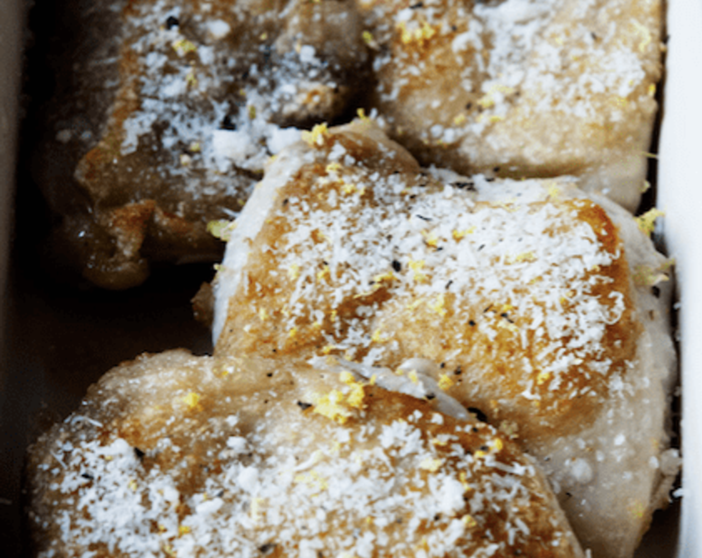 step 8 Transfer chicken to a baking dish, skin up. Sprinkle with Parmesan Cheese (2 Tbsp) and remaining lemon zest.