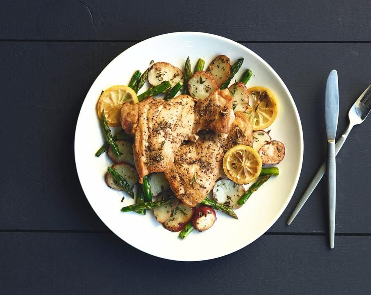 step 15 In the center of two plates, place the chicken, potatoes, and asparagus. Add the lemon for decoration if desired.