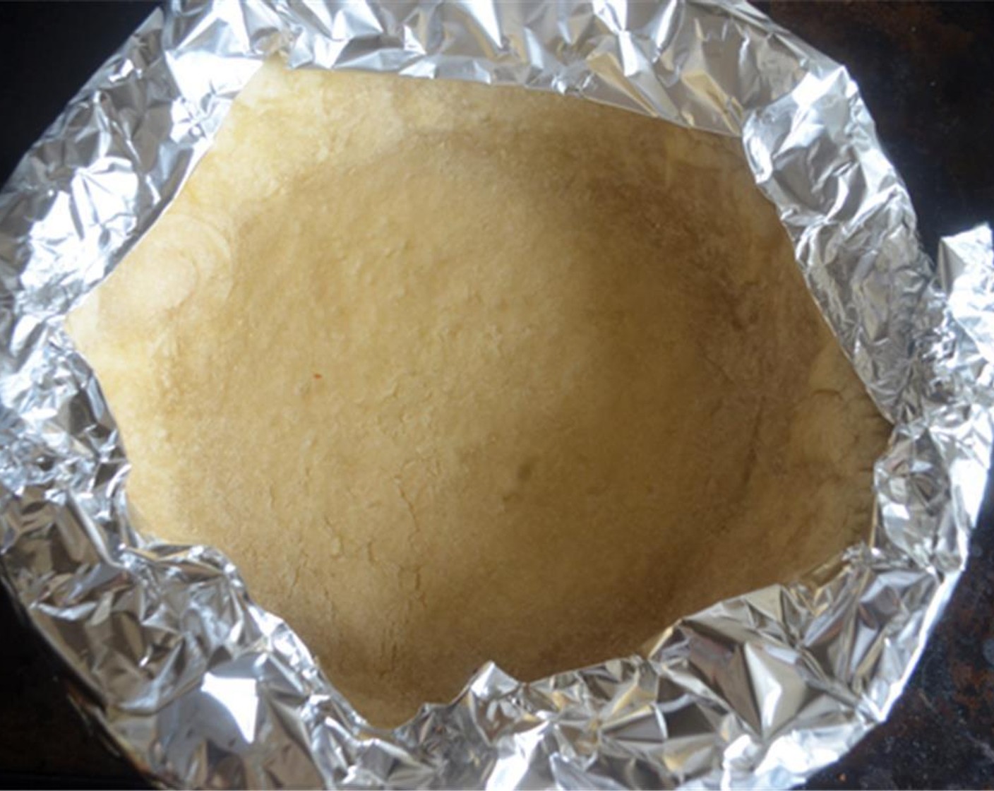 step 10 Take the crust out of the oven; remove the parchment paper and beans or pie weights and tent the edges from getting too dark. Bake for another 20 minutes or until dough is dry and golden. If the bottom puffs up, gently press it down with a flat spatula.