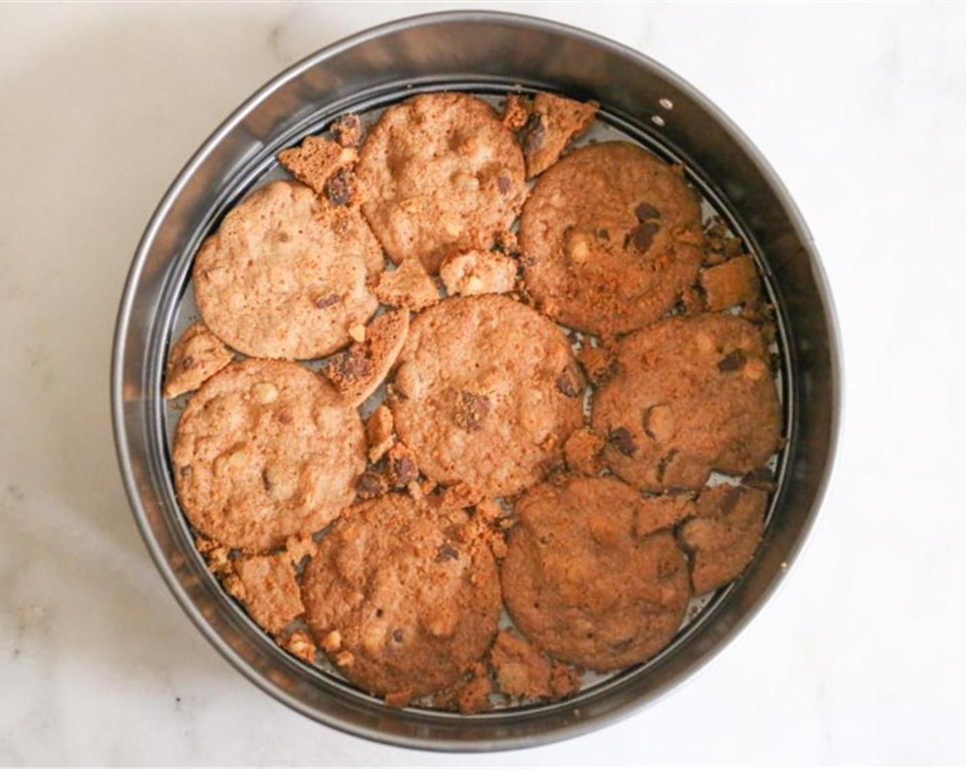 step 3 To assemble the cake, arrange Chocolate Chip Cookies (3 pckg) flat in an 8 or 9-inch springform pan, covering as much of the bottom as possible. Break up a cookie or two to fill in any gaps.