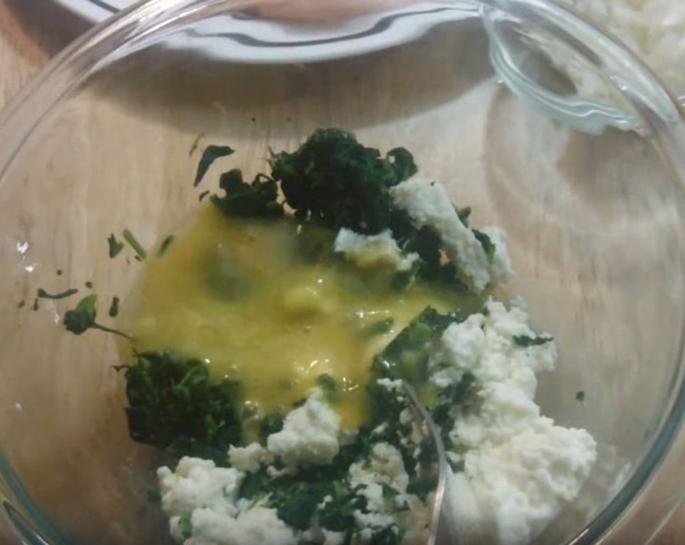 step 2 Into a mixing bowl, add Frozen Spinach (1 cup), Ricotta Cheese (1/2 cup), and Egg (1). Mix well, mashing the cheese to make the mixture as smooth as possible.