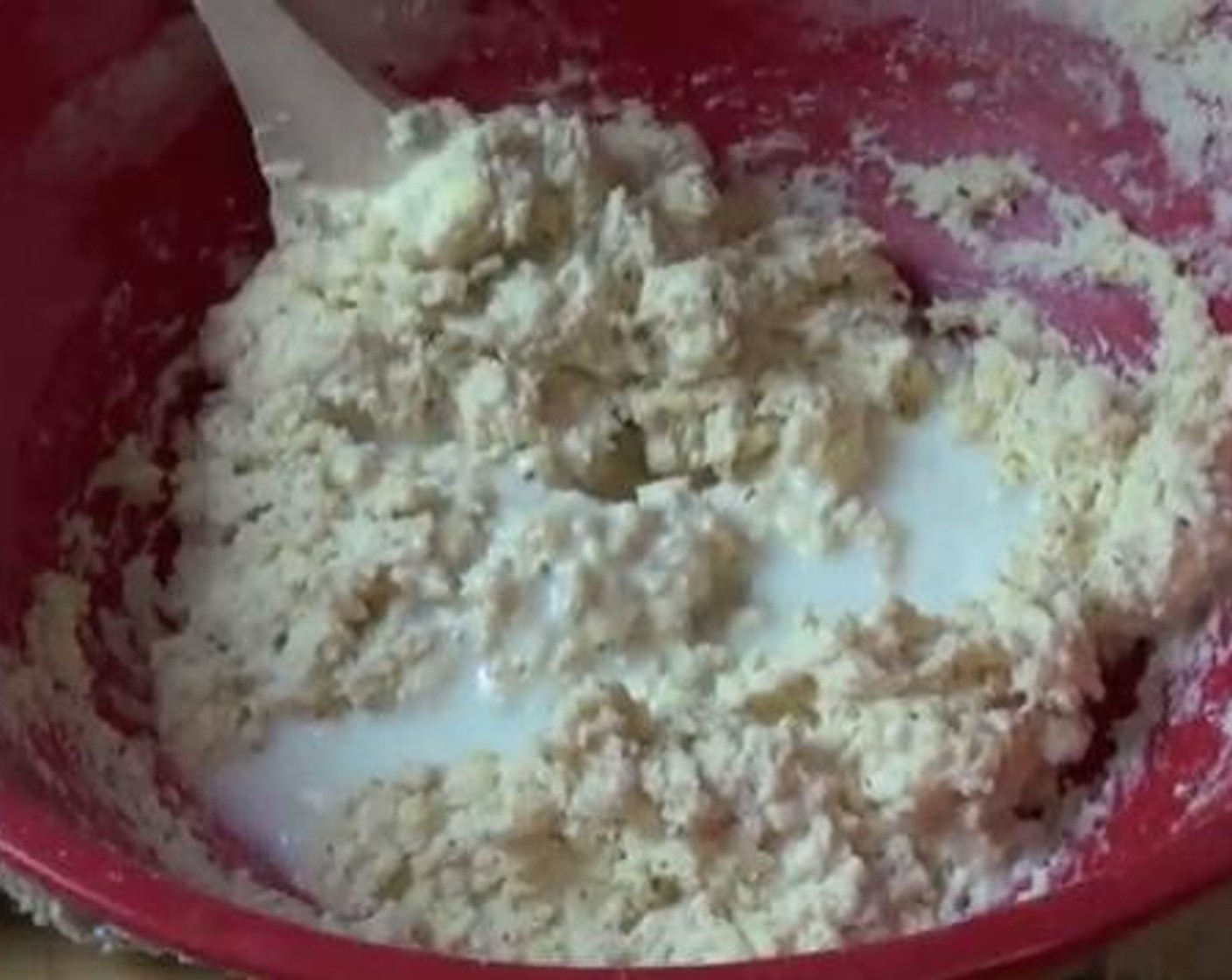 step 4 After mixing well,gradually add the Milk (1 cup) to the bowl together with Water (4 Tbsp). Mix using a spoon.