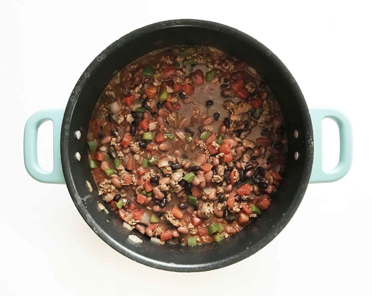 step 5 When the meat is browned and veggies are softening, add Diced Tomatoes (2 cans), Garlic (1 clove), Chili Powder (1 Tbsp), Dried Oregano (1 tsp), Smoked Paprika (1 tsp), Ground Cumin (1 tsp), Salt (to taste), Ground Black Pepper (to taste) and the beans in the stockpot together; cover and simmer for another 30-60 minutes, stirring on occasion. Keep cooking until the beans are soft.
