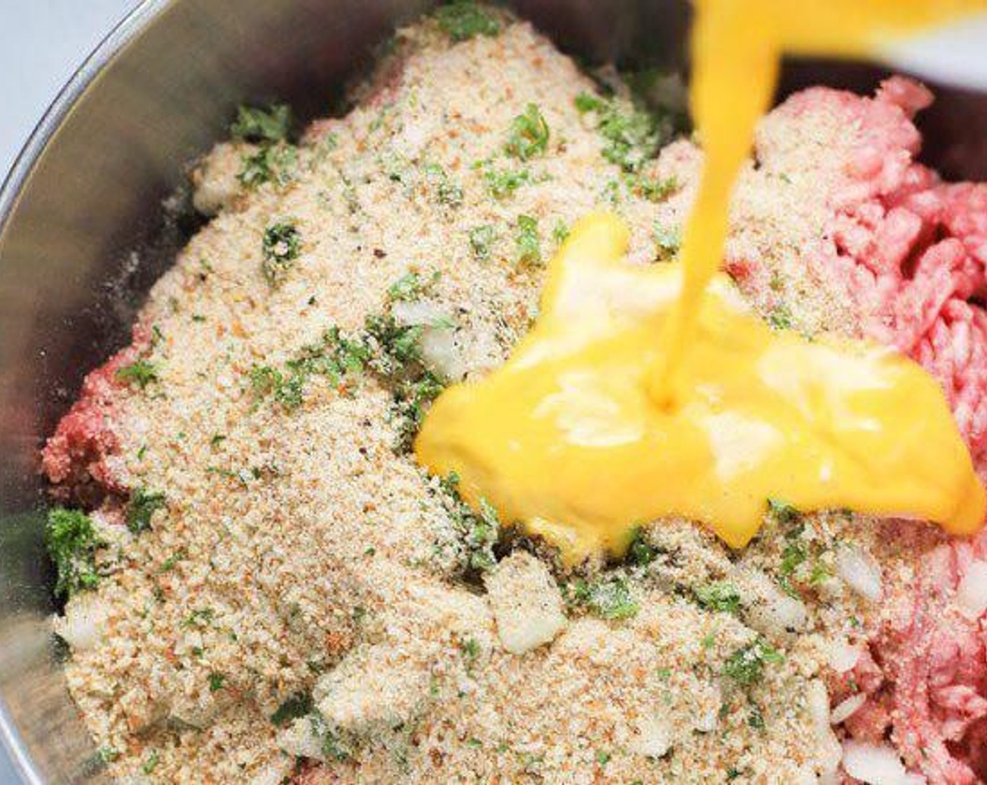 step 3 In a large bowl mix, the 85/15 Lean Ground Beef (1 lb), Ground Pork (1 lb), Onion (3/4 cup), Grated Parmesan Cheese (1/2 cup), Seasoned Breadcrumbs (1/2 cup), Fresh Parsley (2 Tbsp), Salt (1/2 Tbsp), Ground Black Pepper (1/2 tsp), and beaten eggs.