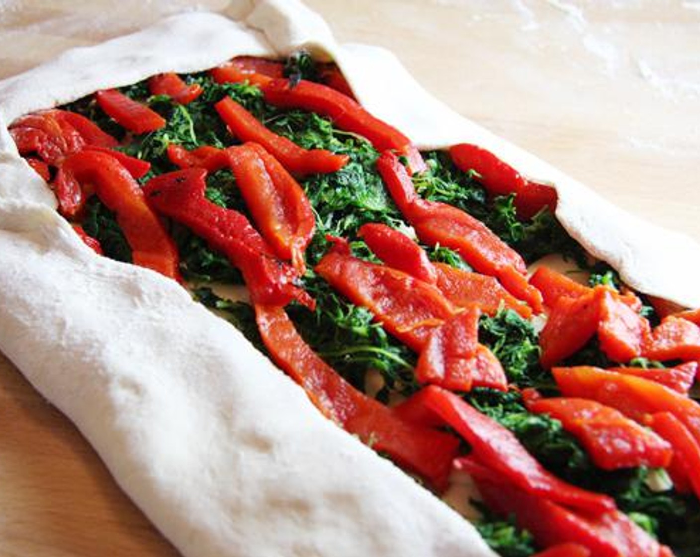 step 4 Top mixture with overlapping Provolone Cheese (12 slices). Add the Frozen Spinach (2 cups) in an even layer. Finally, add the Roasted Red Pepper Strips (2 cups) in a single layer, long sides parallel to the long sides of the dough rectangle.