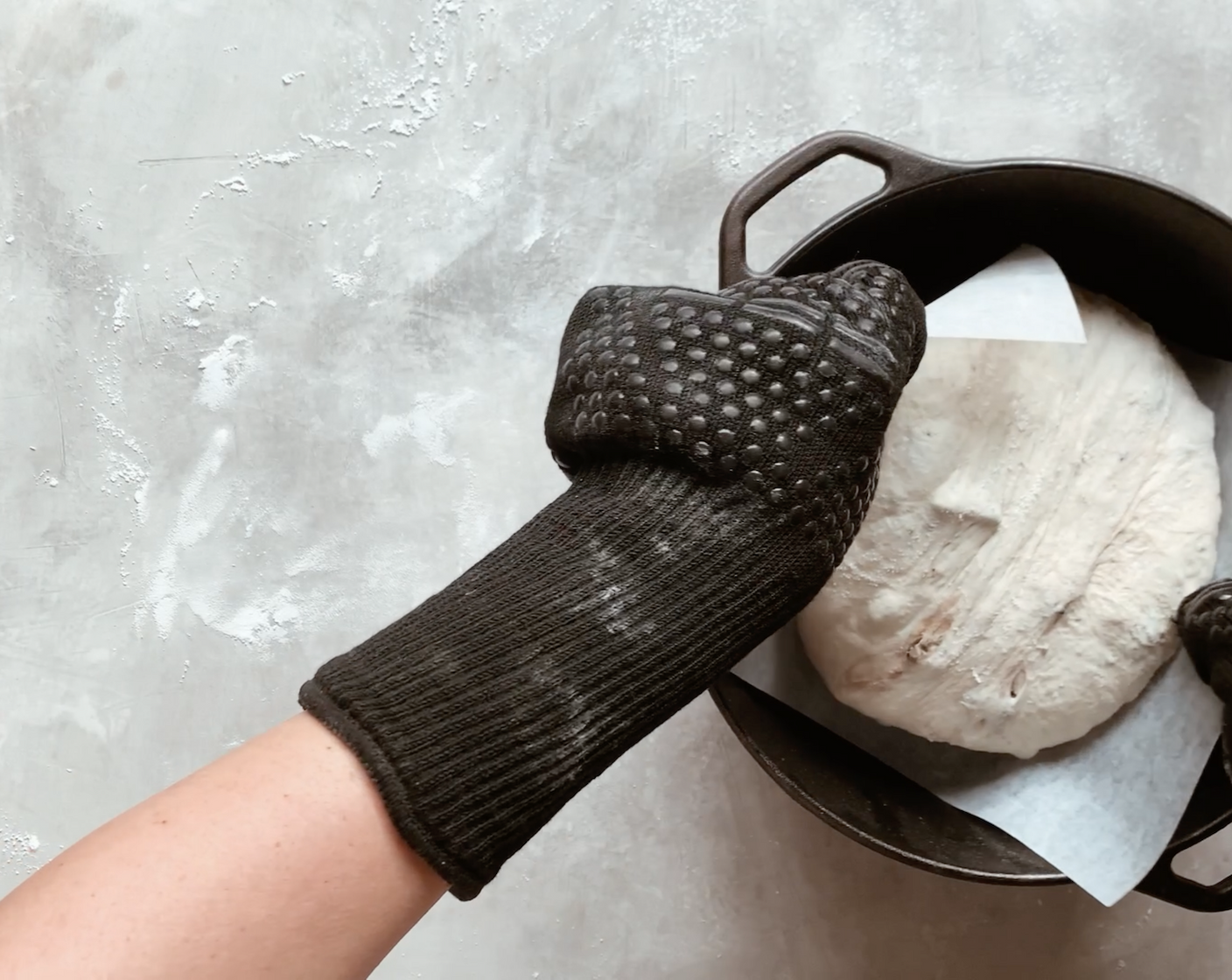 step 11 Use oven-proof gloves/mitts to carefully remove the pre-heated Dutch oven from the oven, and place it on a trivet or on your stovetop. Remove the lid, pick up the parchment paper with the dough on it, and carefully place it in the dutch oven. Put the lid back on and bake, covered for 25 minutes.