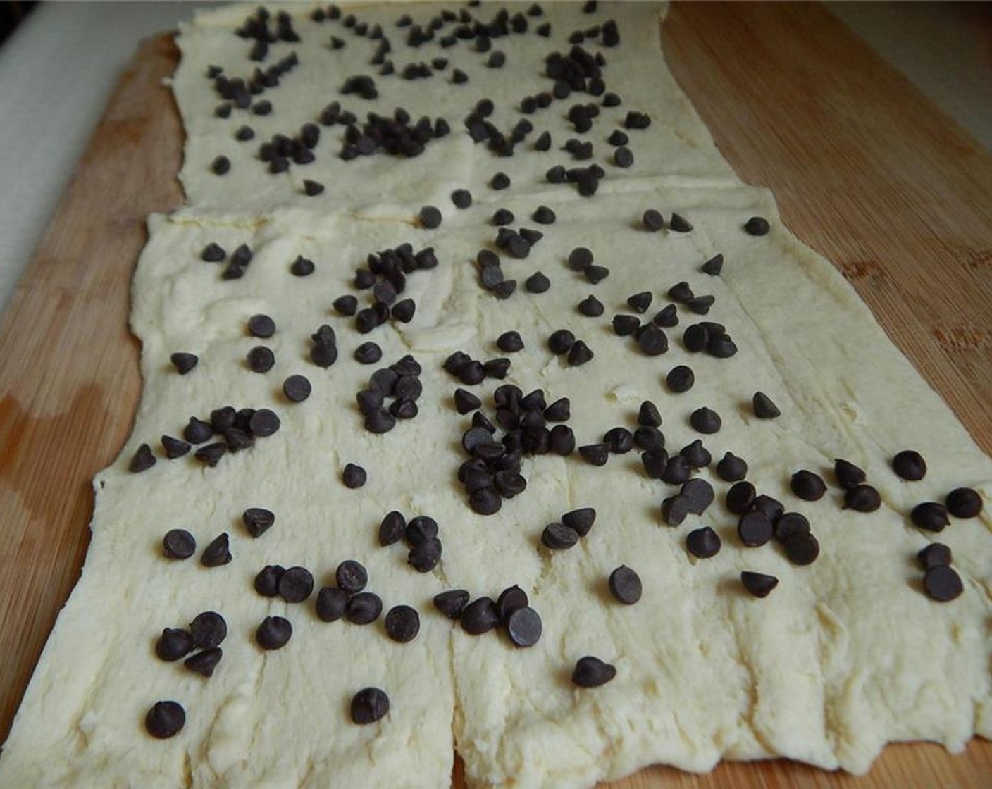 step 3 Unroll Pillsbury™ Reduced Fat Crescent Rolls (1 pckg) and make one large piece of dough with all 8 rolls. Sprinkle the Mini Chocolate Chips (2 Tbsp) evenly over dough.