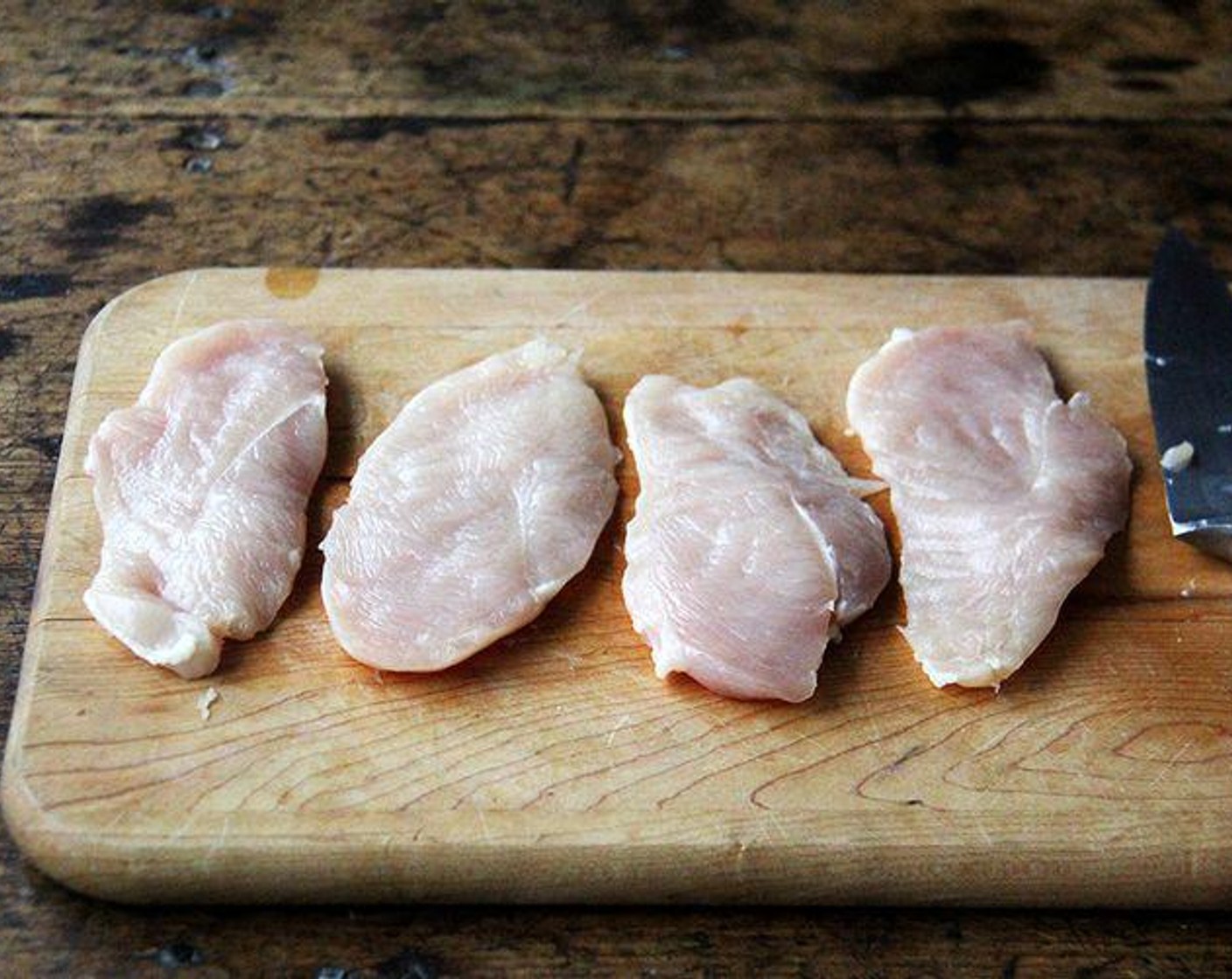 step 3 Meanwhile, prepare the Chicken Breasts (2): if the tenderloin is still intact, slice it off and set it aside. At this point, you can either pound the chicken breasts to a 1/2-inch thickness, or you could cut each breast in half crosswise, to create 4 thin pieces.