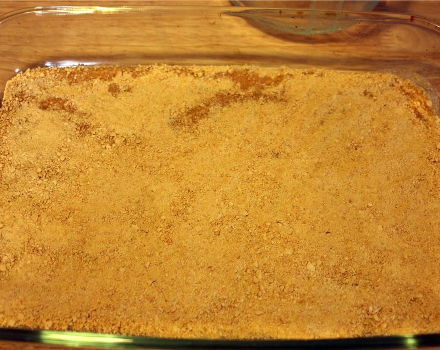 step 4 Sprinkle the Graham Cracker Crumbs (1 1/2 cups) on to the melted butter so that it is completely covered. Make sure you distribute the crumbs evenly. Once covered, pat the crumbs down a bit to make sure they stick together well.