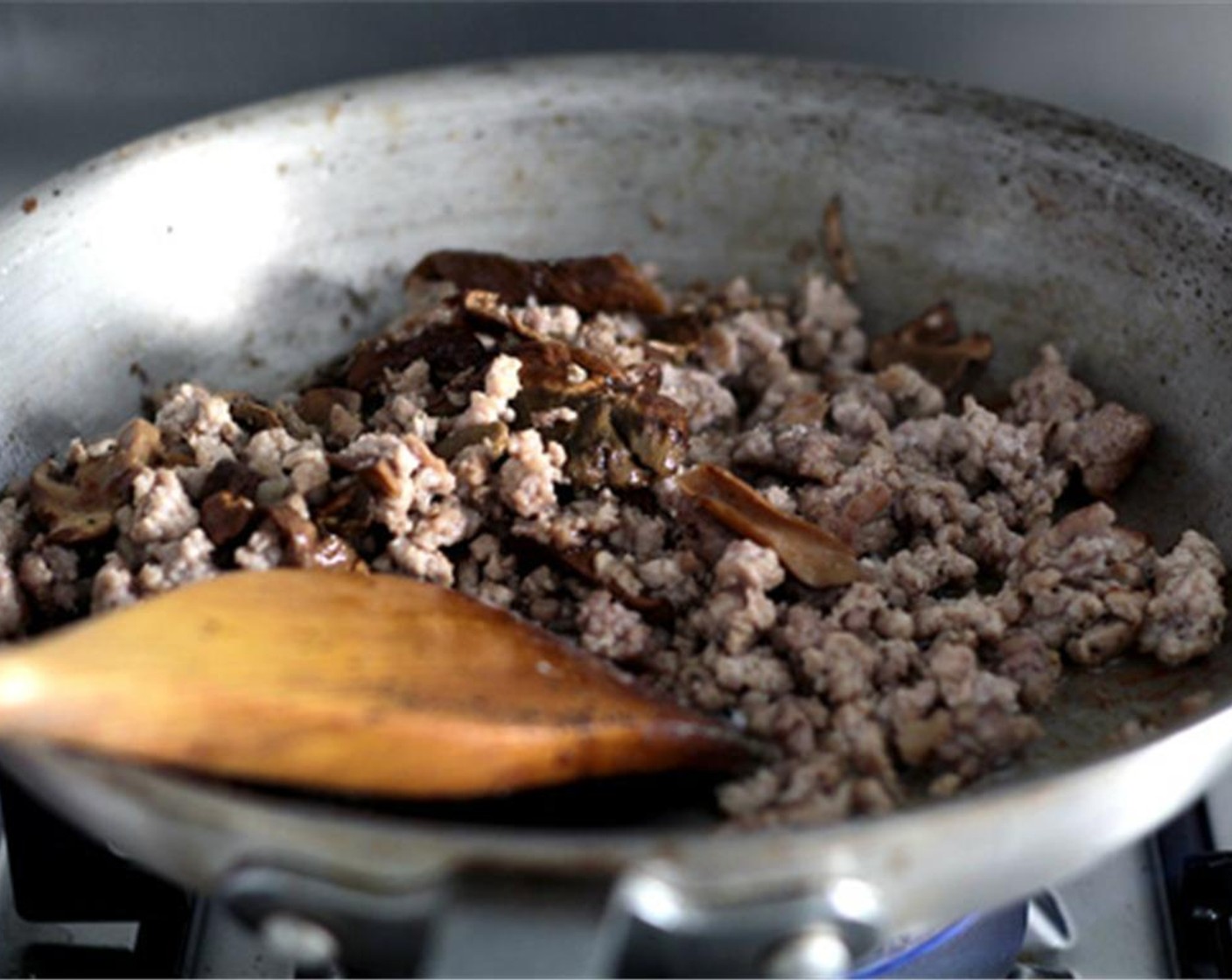 step 17 Add Extra-Virgin Olive Oil (2 Tbsp) in the skillet and the Anchovies (2), break it up with a wooden spoon until it melts into the oil. Add ground pork, breaking it up with a wooden spoon and cook until evenly browned.