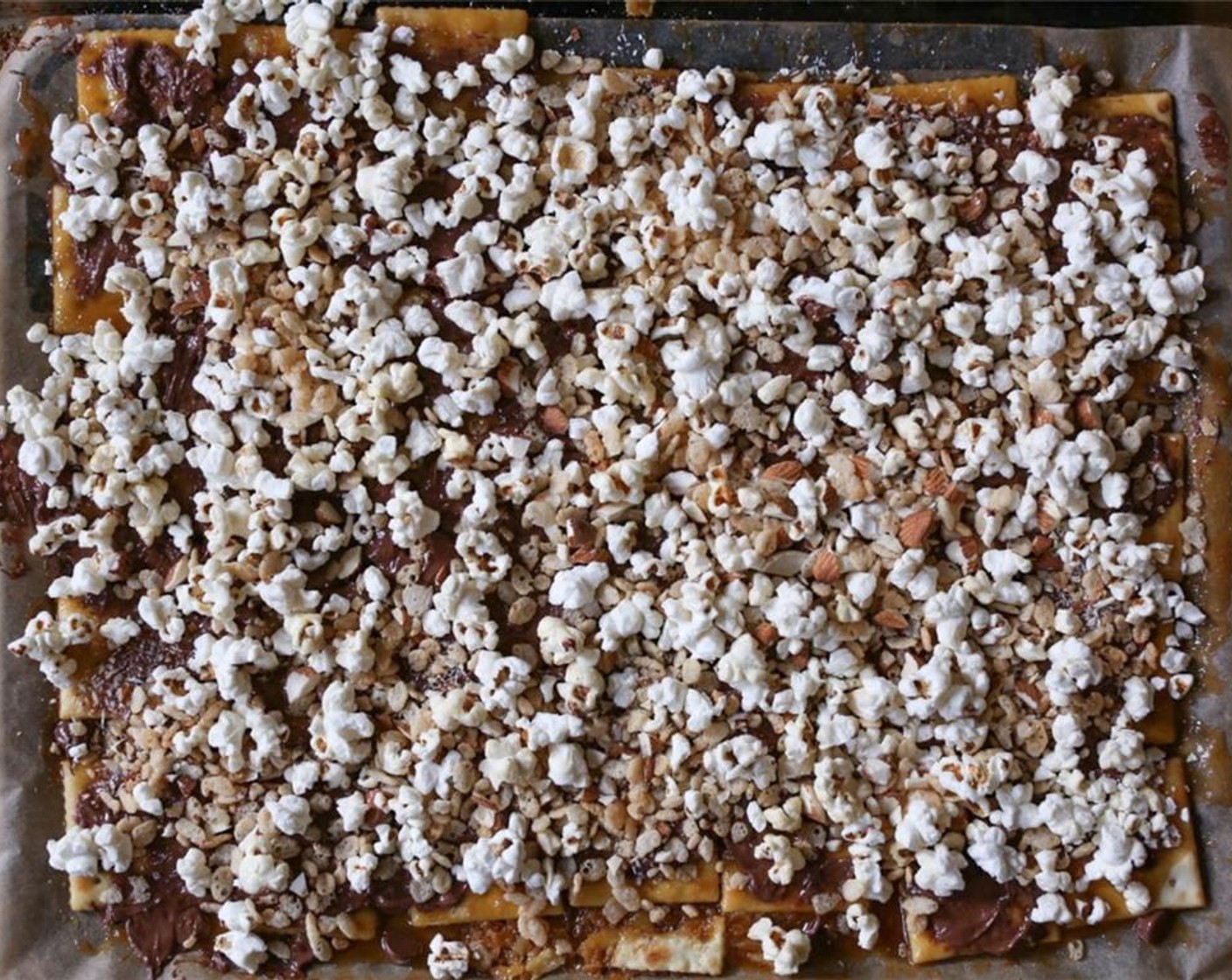 step 7 Using a spatula, quickly spread the chocolate chips all over the top of the toffee. Immediately add Popcorn (2 1/3 cups), Rice Krispies® Cereal (2/3 cup), and Raw Almonds (1/2 cup) in an even layer. It’s important that you do this fast so the toppings stick.