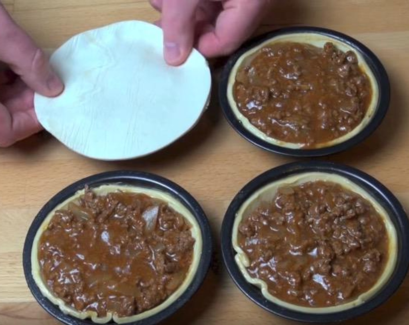 step 5 Divide the meat mixture between the 4 pies. Brush edges of pastry with some of the Eggland's Best Classic Egg (1). Cover each pie with a puff pastry circle and press down around the edges to seal.