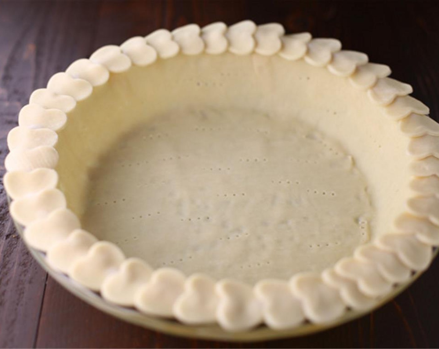 step 4 Brush the edge of the pie crust with a little bit of water (the one in the pie plate). Add hearts around the edge of pie crust.