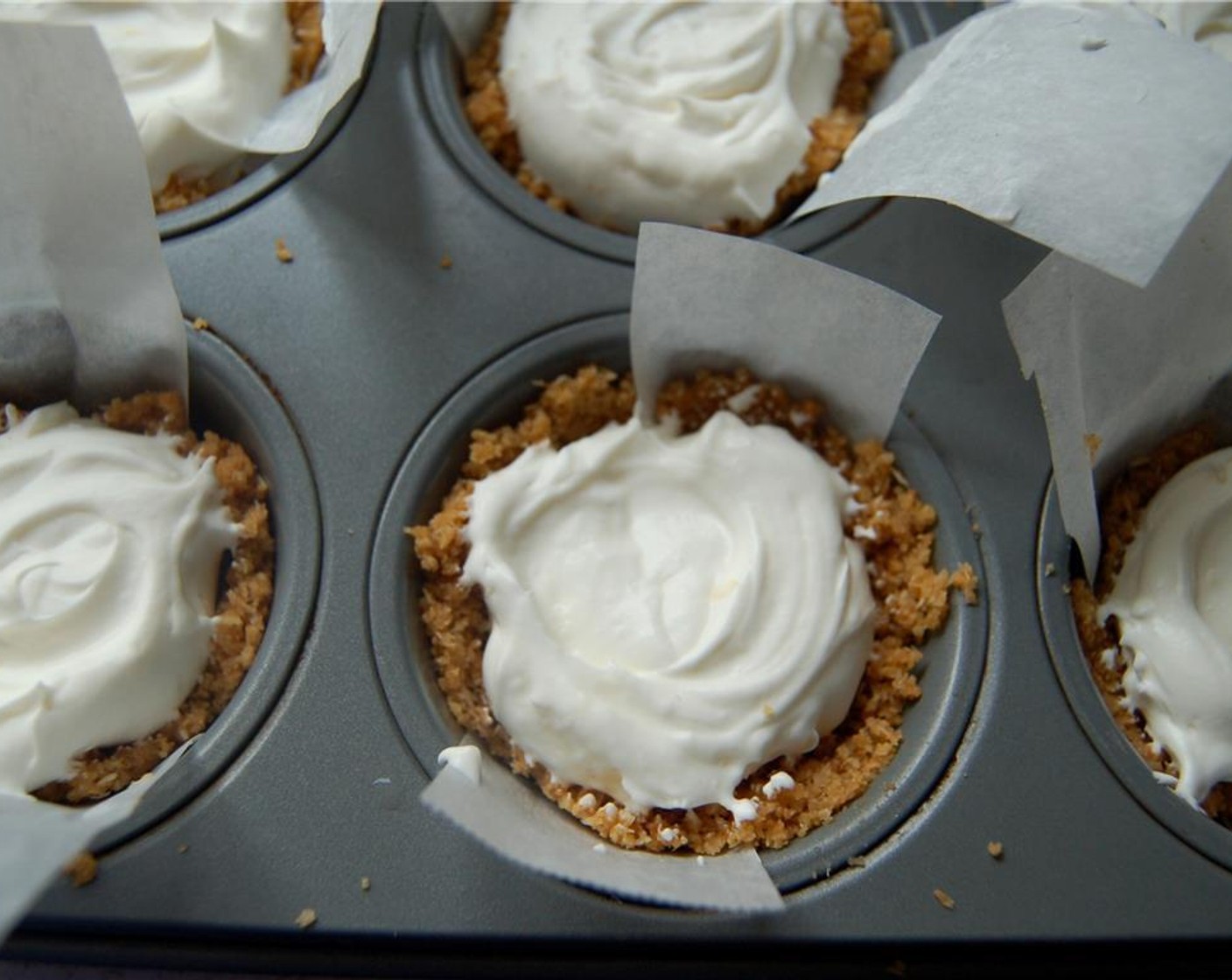 step 6 Take cupcake tin out of the freezer. Divide the cheesecake mixture evenly between all of the cups (a cookie scoop works well).