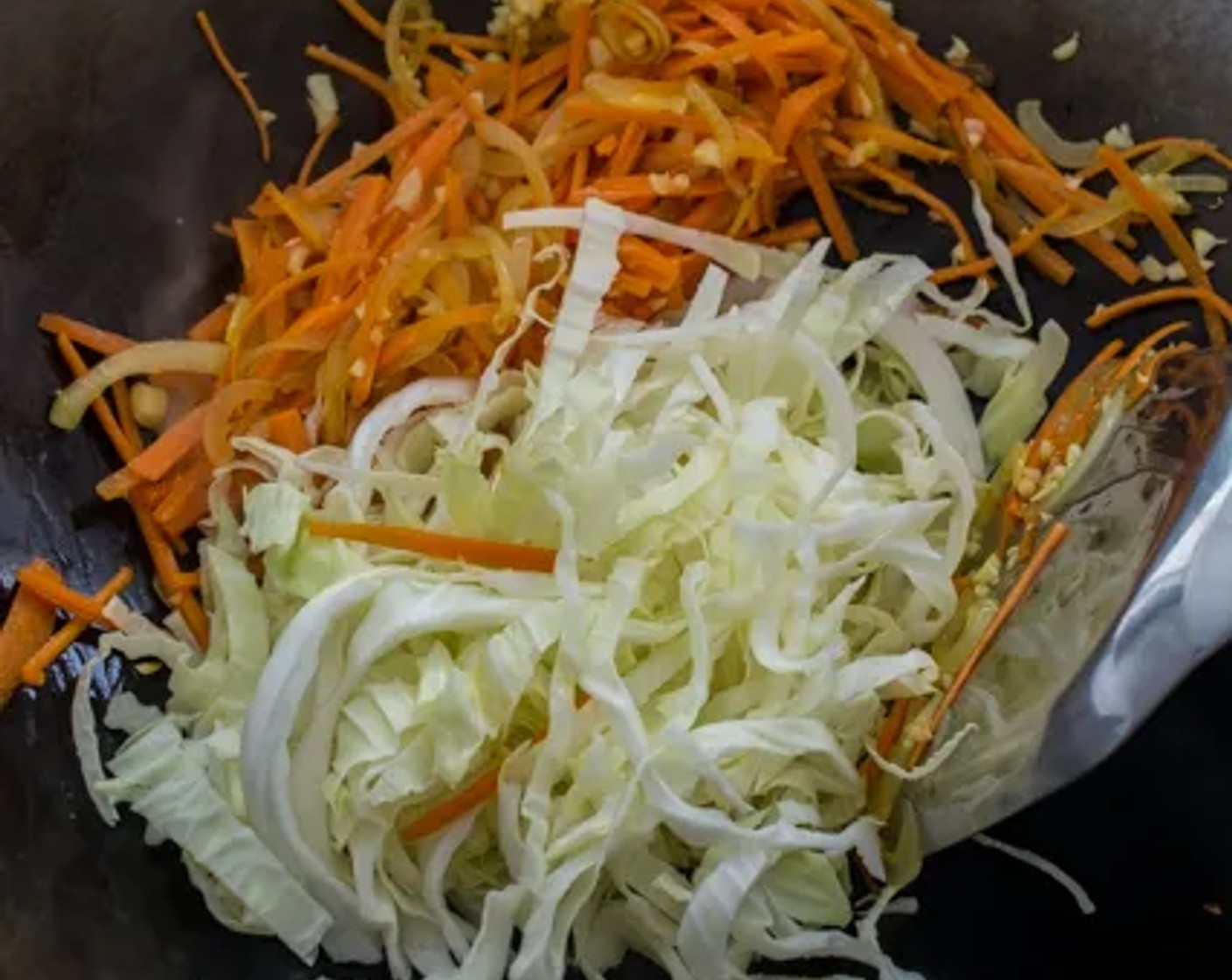 step 5 As soon as the onions have softened, stir in Garlic (3 cloves) and White Cabbage (2 cups). Stir-fry till the cabbage is slightly soft, then remove the vegetables from the wok and set aside.