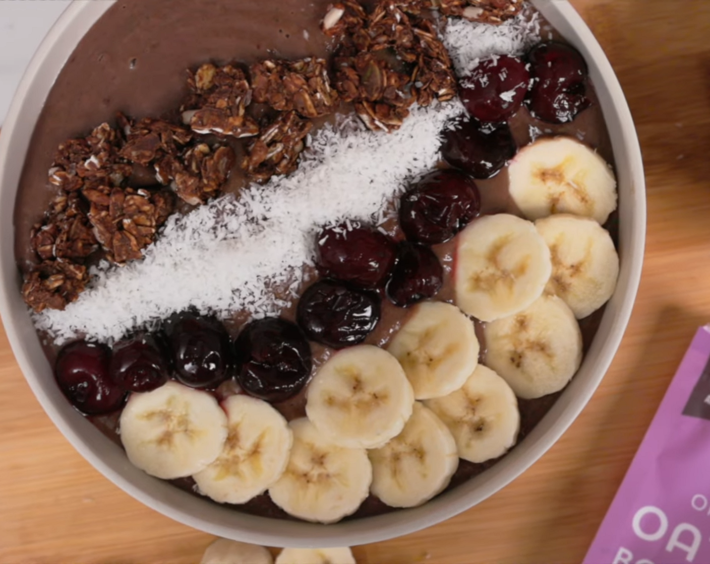 step 2 Pour smoothie into a bowl. Top with Chocolate Oat Clusters (to taste), Unsweetened Shredded Coconut (1/4 cup), Bananas (to taste), and Cherries (to taste) on top of the smoothie bowl.