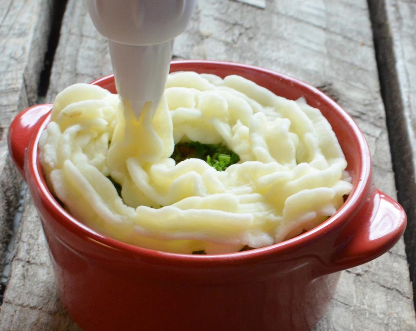 step 11 You can then spoon or pipe the mashed potatoes over the top. If you spoon it, flatten it a little over the top and with a fork make some lines on top.