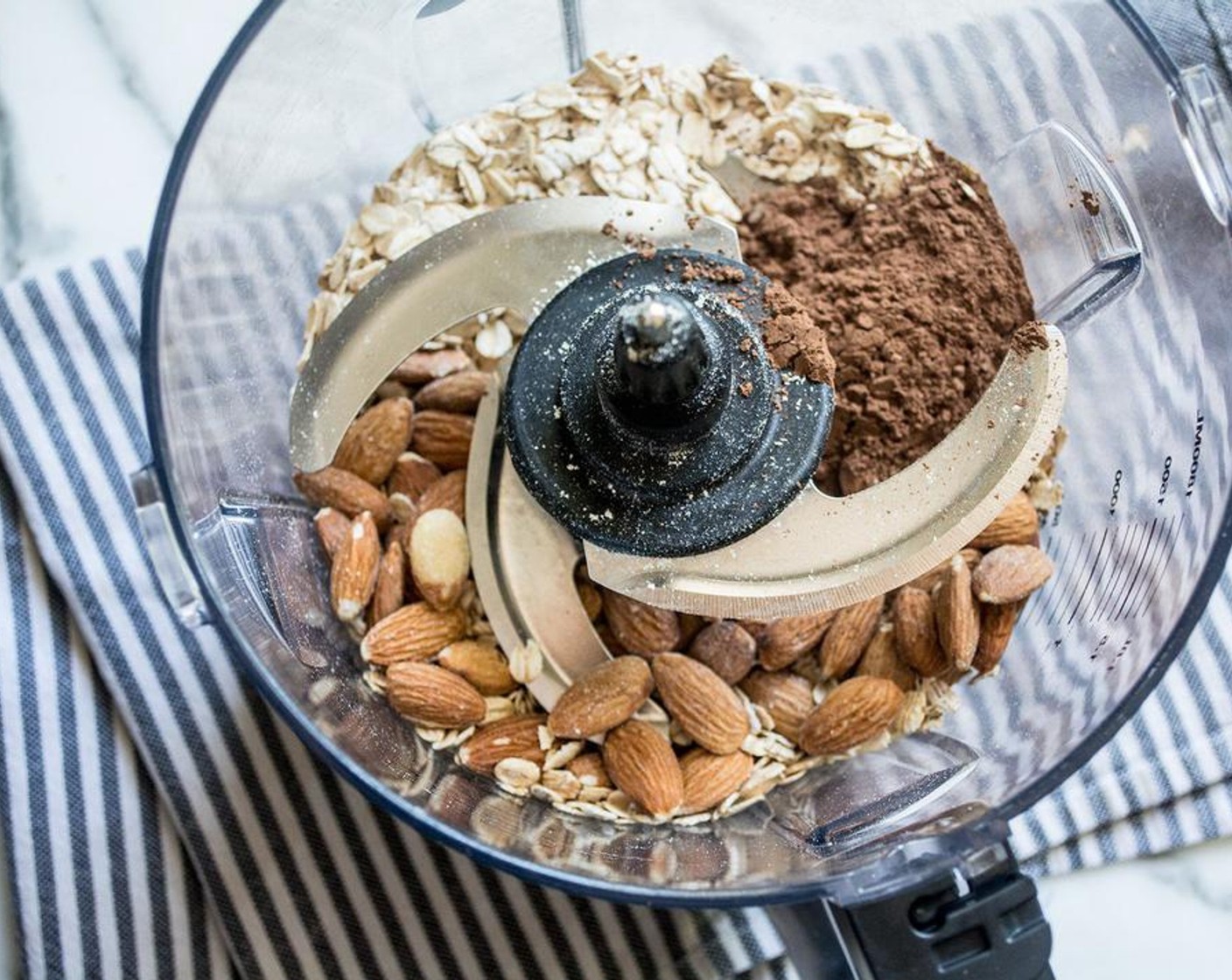 step 1 Add Raw Almonds (1 cup), Oats (1 cup), and Unsweetened Cocoa Powder (4 Tbsp) to the bowl of a food processor, process 10 to 20 seconds or until a course flour forms.